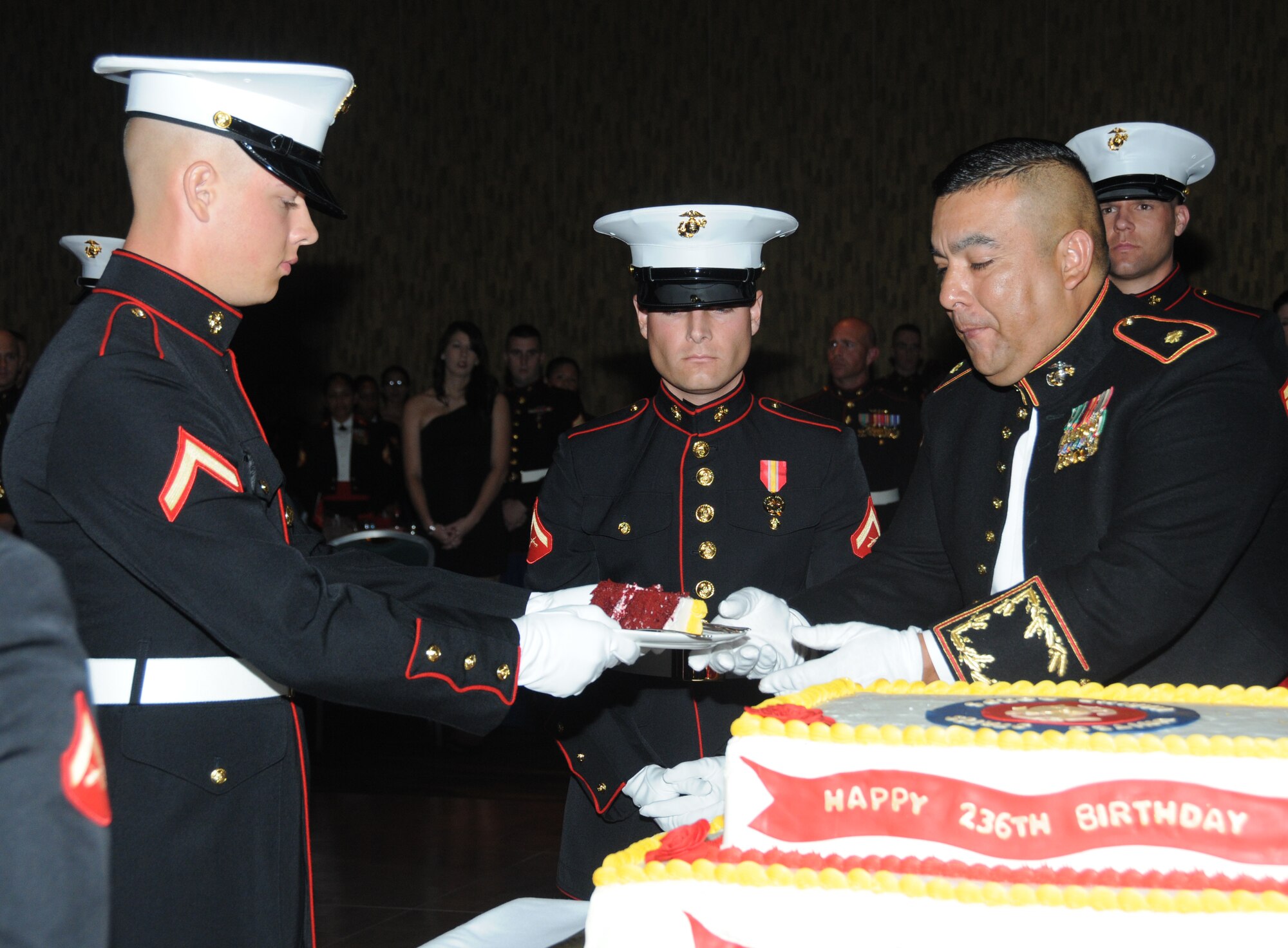PFC. Jordan Fleet, Keesler Marine Corps Detachment, receives a piece of cake from Maj. Nieves Villasenor, MARDET Commanding Officer, as Lance Cpl. Adam Bouwman watches during the Marine Corps Ball Nov. 10, 2011, at the Mississippi Coast Coliseum Convention Center in Biloxi, Miss.  Villasenor was the Oldest Marine present and Fleet was the youngest Marine present.  (U.S. Air Force photo by Kemberly Groue)
