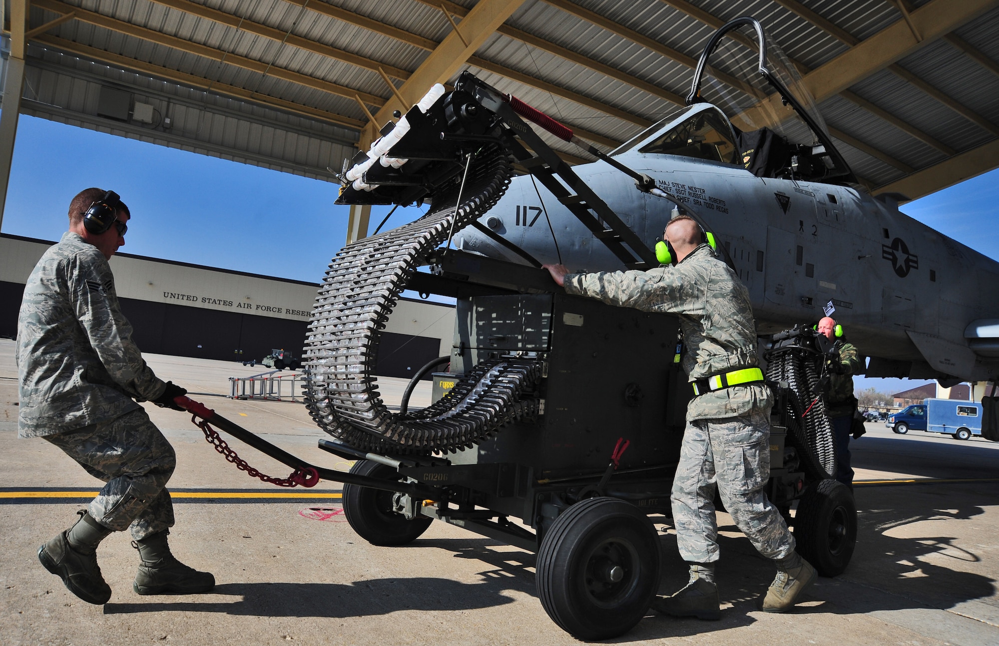 Weapons loading Airmen from the 442nd Aircraft Maintenance Squadron pull away empty A-10 shell cartridges after loading trainer rounds into an A-10 Thunderbolt II here Nov. 4. After every 25,000 rounds the A-10 cannon fires, the entire weapon system comes out of the airplane for an inspection. (U.S. Air Force photo/Senior Airman Nick Wilson)