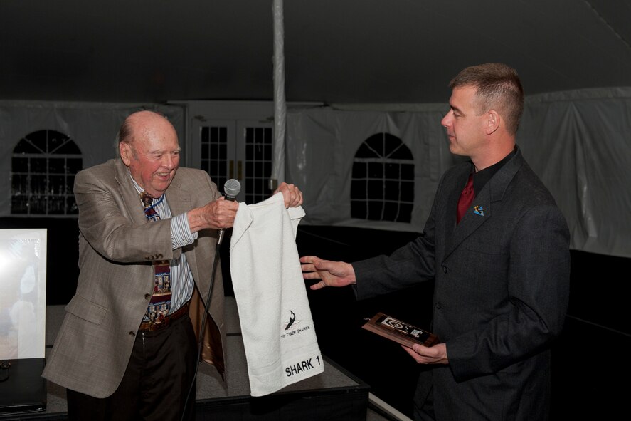 Retired U.S. Air Force Col. Kirk Kirkpatrick, World War II era 75th Fighter Squadron pilot, presents gifts to Lt. Col. David Trucksa, 75th FS commander, during the 2011 Flying Tigers Reunion dinner in Tampa, Fla., Nov. 12, 2011. Before presenting the gifts, Kirkpatrick spoke about how grateful he was for the honor shown by the 75th FS during a memorial service earlier in the year for Maj. Gen. Johnny Alison, an original Flying Tiger member. (U.S. Air Force photo by Staff Sgt. Jamal D. Sutter/Released)