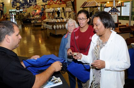 Juan Guerra, 902 Mission Support Group, Civil Engineering Environmental Flight, informs members of the base community on products made from recycled material as part of America Recylces Day, Nov. 15. Membershad an opportunity to learn more about recycling and to visit the recycling kiosk set up inside the Base Exchange with free promotional items made from recycled material. (U.S. Air Force Photo by Don Lindsey)