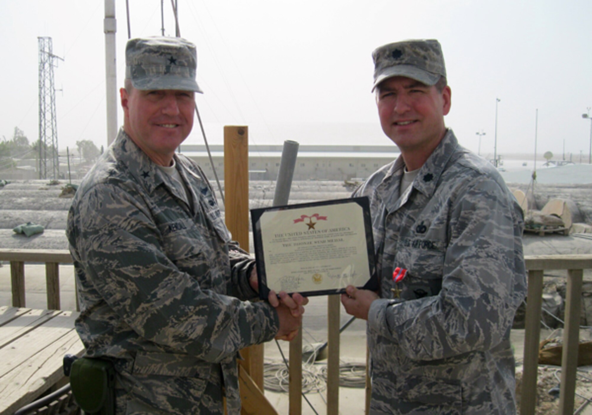 Brig. Gen. Jeffrey B. Kendall, commander, Kandahar Airfield, Afghanistan, presents Lt. Col. Timothy Martz, 94th Security Forces Squadron commander, with the Bronze Star Medal for exceptionally meritorious service in direct support of combat operations while deployed as Chief Base Security and Base Security Group commander in Kandahar Afghanistan. While assigned to the NATO Command Kandahar Airfield (COMKAF) Headquarters, Martz commanded over 700 personnel from 9 nations. Their primary mission was to protect and defend Kandahar Airfield from insurgent attacks. (Courtesy photo)
