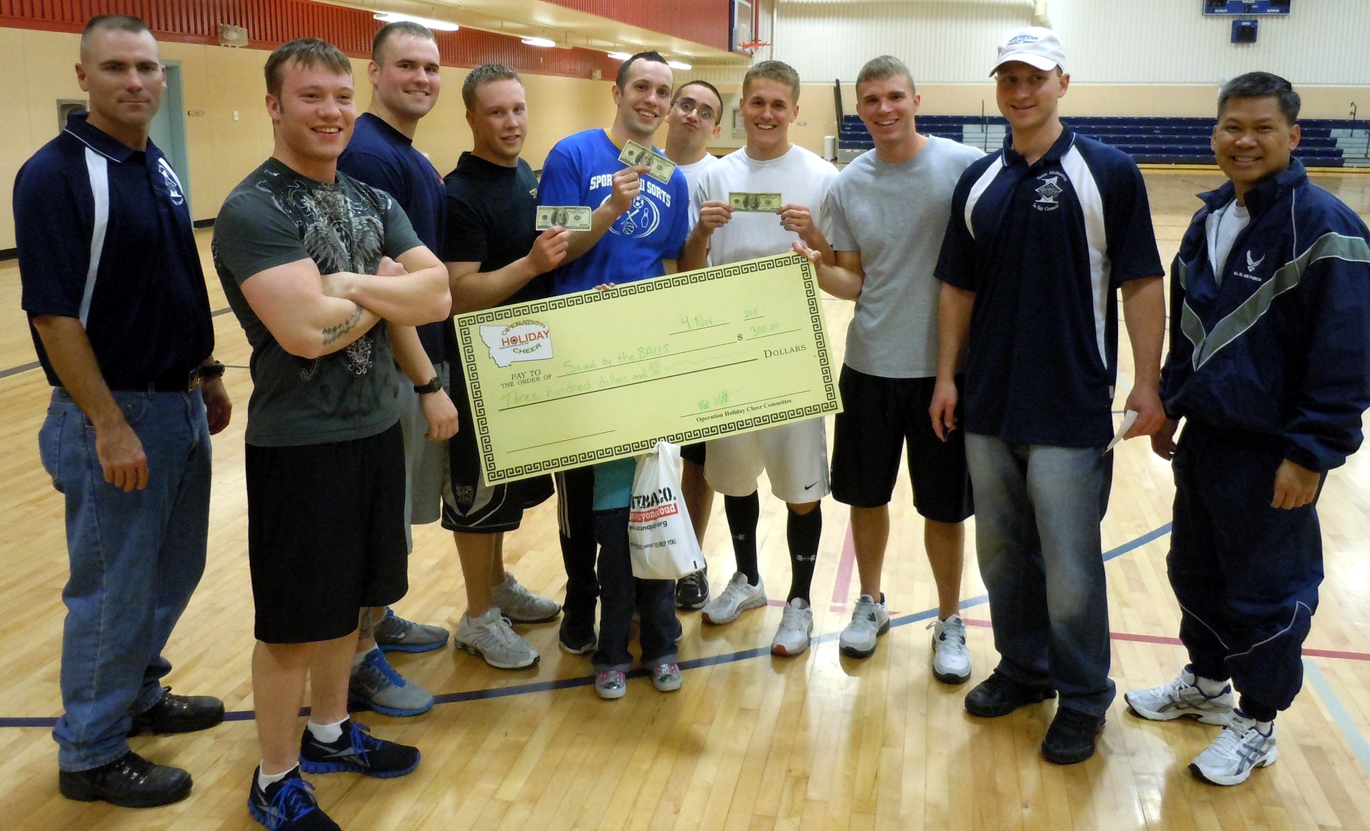 Members of the 341st Missile Security Forces Squadron Alpha Flight pose with their $300 first-place prize for winning the dodgeball tournament, the first of four events for this year's Operation Holiday Cheer. Pictured from left to right are Master Sgt. Shane Matt, event coordinator; Staff Sgt. Brandon McDonald; Senior Airman Justin McEwen; Senior Airman Michael Warren; Airman 1st Class Justin Wallace; Airman 1st Class Christopher Lamay; Airman 1st Class Cody Rosenberger; Senior Airman Jeremy Burton; Master Sgt. Bradley Thye, event coordinator; and Col. H.B. Brual, 341st Missile Wing commander. The next event is a 9-pin no-tap bowling tournament Nov. 18. Call 731-2695 to sign up.