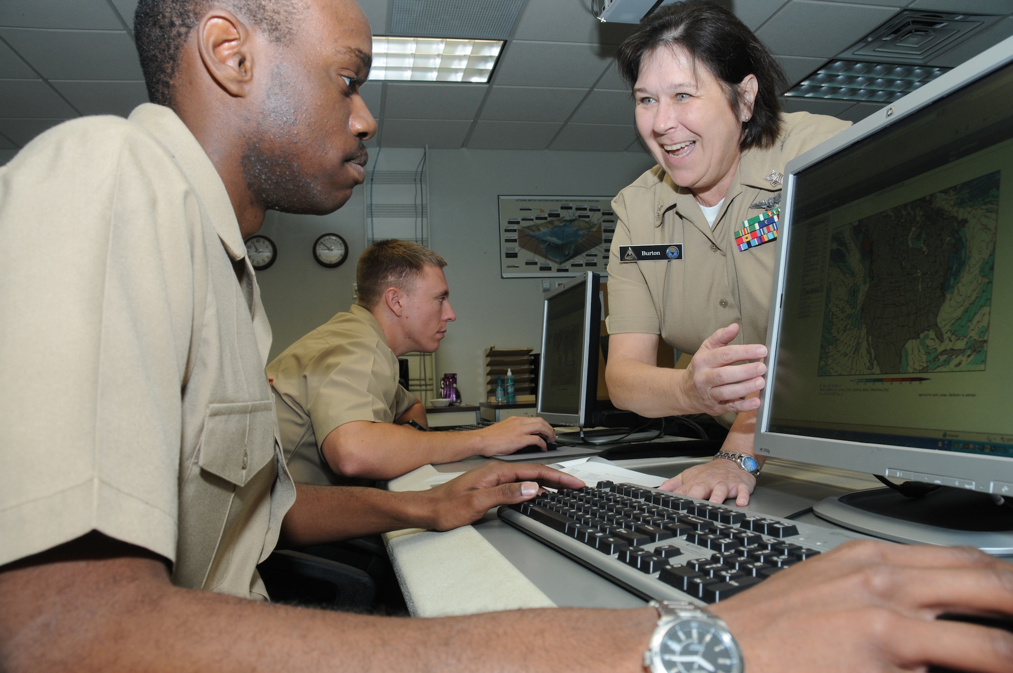 Seaman Recruit Robert Thompson, Keesler Center for Naval Aviation Technical Training Unit, receives help from his instructor, Petty Officer 1st Class Cynthia Burton, CNATTU, during aerographer’s mate A-School at the weather training building, Nov. 14, 2011, at Keesler Air Force Base, Miss.  Burton is the 2011 recipient of the Thomas V. Fredian Community Leadership Award.  (U.S. Air Force photo by Kemberly Groue)

