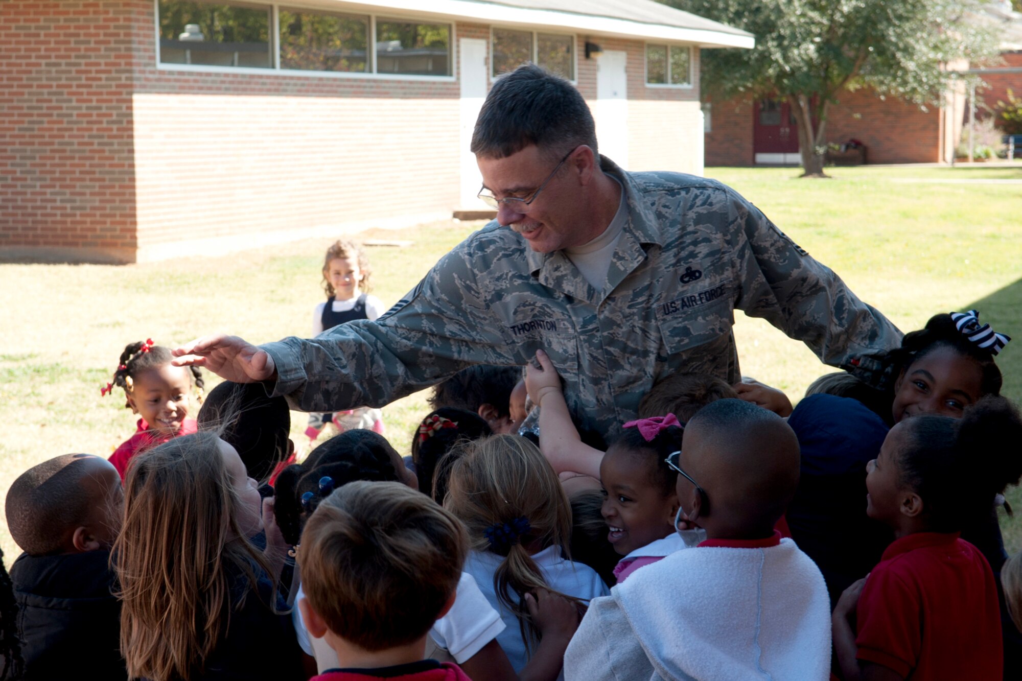 U.S. Air Force Senior Master Sgt. Mike Thornton, 917th Aircraft Maintenance Squadron production superintendent, gets mobbed on the playground by a group of Phoenix Magnet Elementary students during his visit on Nov. 10, 2011. The school, located in Alexandria, La., hosted a group of 917th Fighter Group personnel who they have adopted to support during future deployments. (U.S. Air Force photo by Master Sgt. Greg Steele/Released)