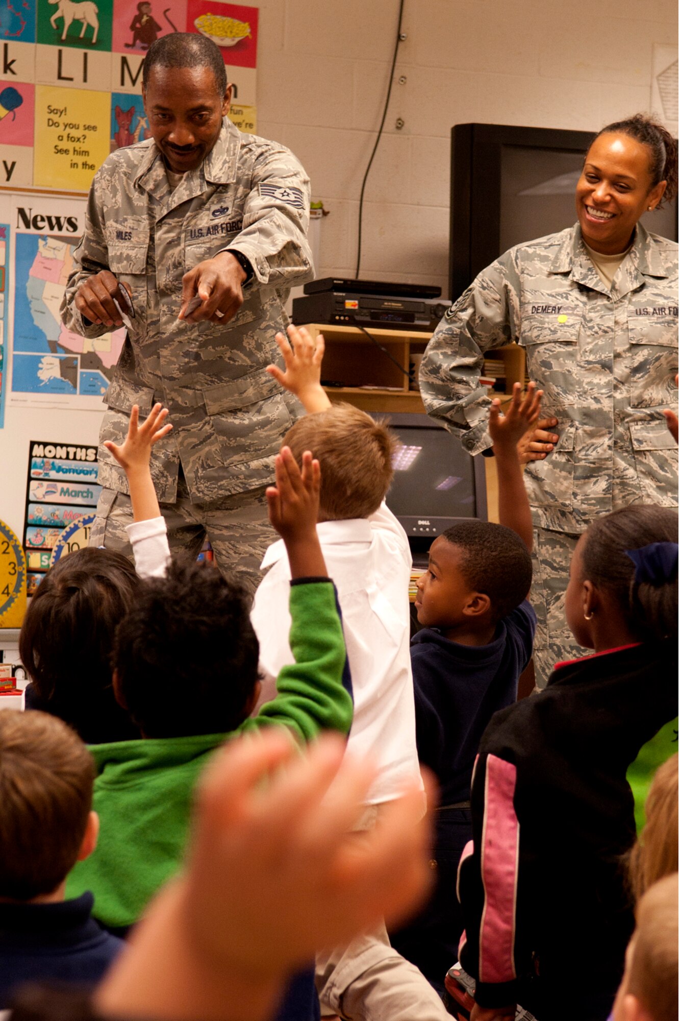 U.S. Air Force Tech. Sgt. April Demery watches as Tech. Sgt. Curtiss Miles, 717th Aircraft Maintenance Squadron crew chief, picks a kindergarten student in hopes of getting a right answer to a question so he can hand out an A-10 Thunderbolt II sticker, Phoenix Magnet Elementary School, Alexandria, La., Nov. 10, 2011. The school hosted a group of 917th Fighter Group personnel, who visited all 675 students, answering questions about themselves, their jobs and the Air Force Reserve. (U.S. Air Force photo by Master Sgt. Greg Steele/Released)