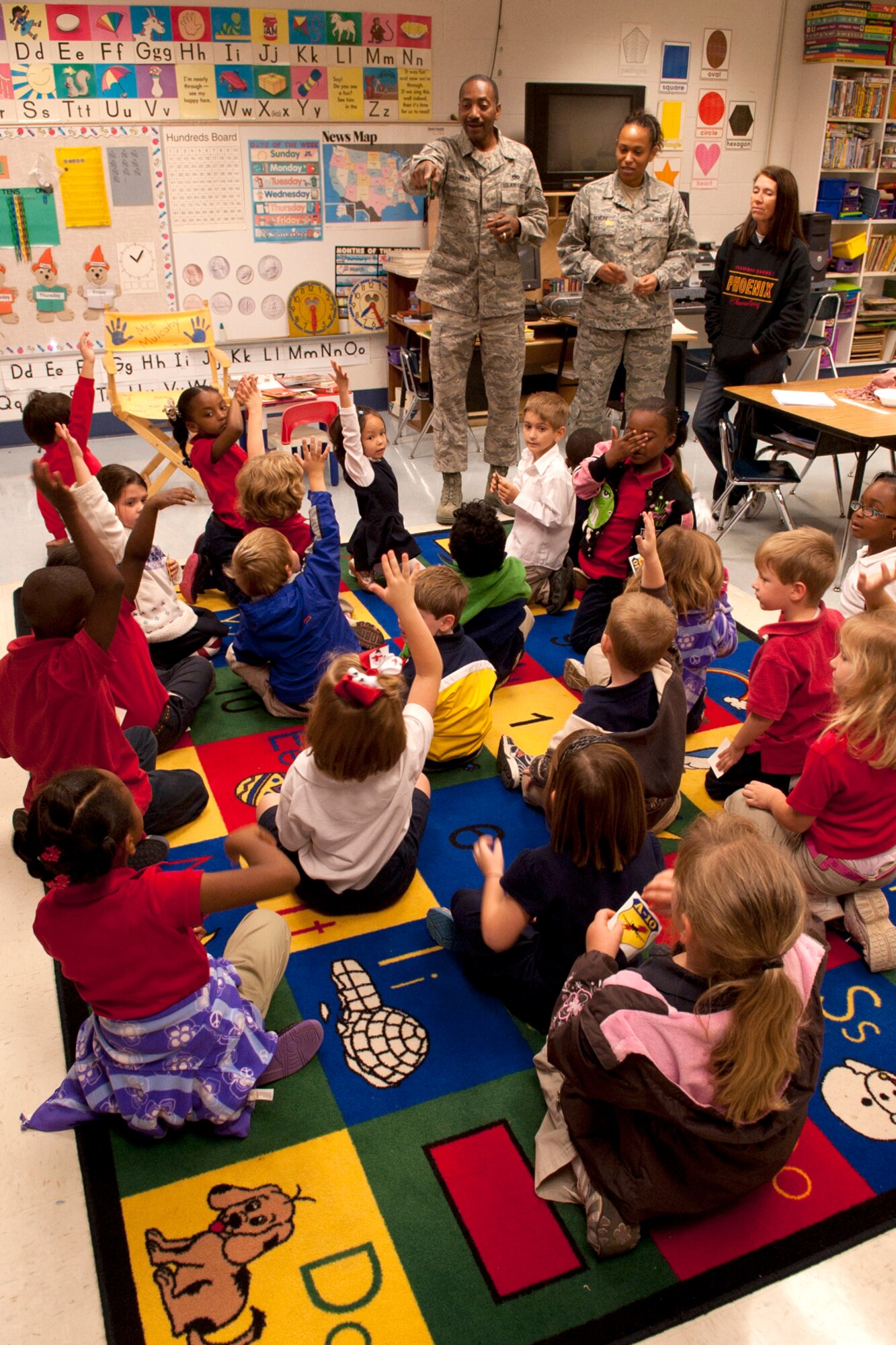 U.S. Air Force Tech. Sgts. Curtiss Miles and April Demery interact with kindergarten students at the Phoenix Magnet Elementary School, Alexandria, La., Nov. 10, 2011. The school hosted a group of 917th Fighter Group personnel, who visited all 675 students, answering questions about themselves, their jobs and the Air Force Reserve. (U.S. Air Force photo by Master Sgt. Greg Steele/Released)