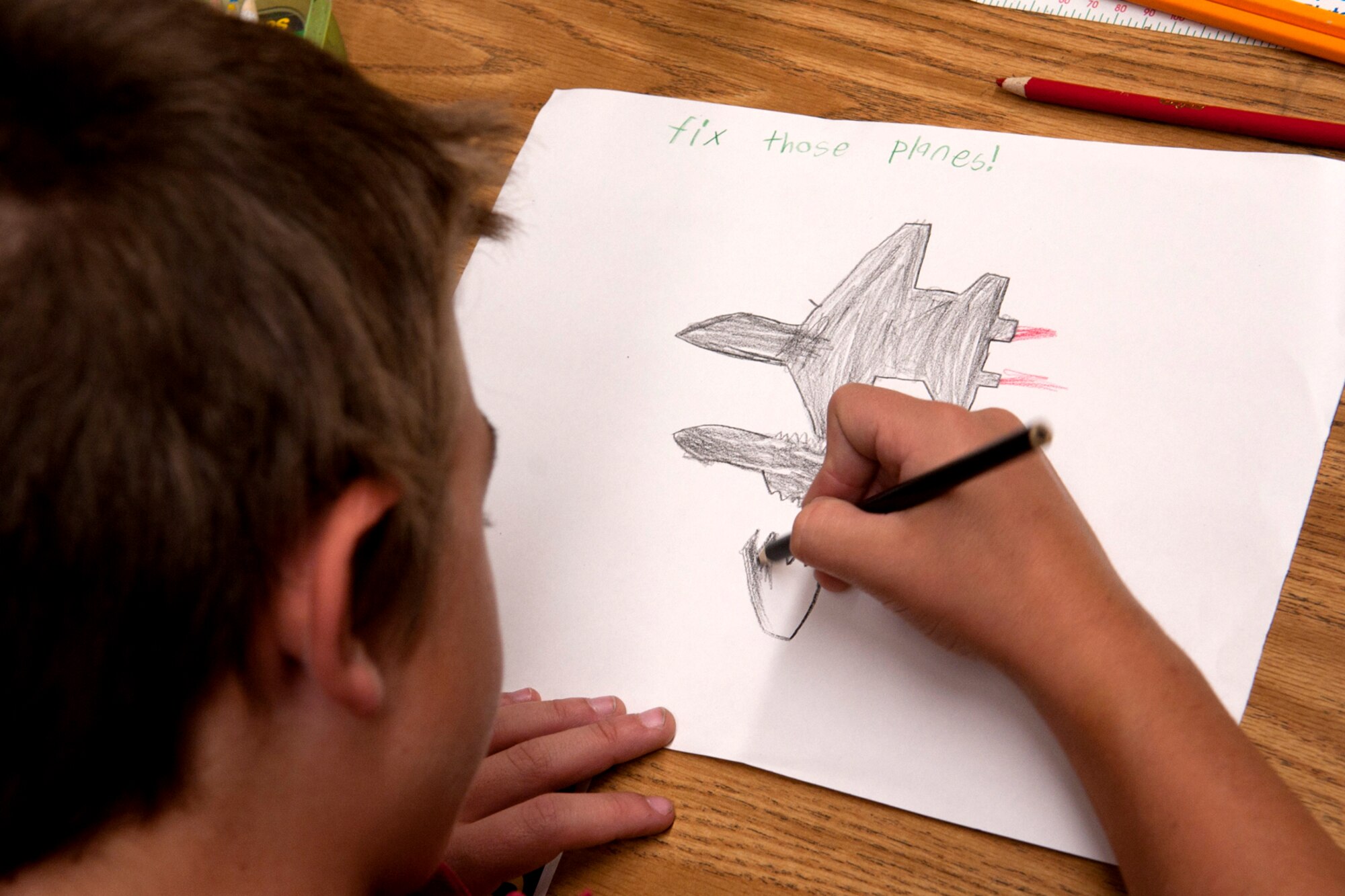 A student at the Phoenix Magnet Elementary School draws a picture for members of the 917th Fighter Group who visited the school in Alexandria, La., Nov. 10, 2011. The school hosted a group of 917th Fighter Group personnel, who visited all 675 students, and received cards and letters from the students. (U.S. Air Force photo by Master Sgt. Greg Steele/Released)