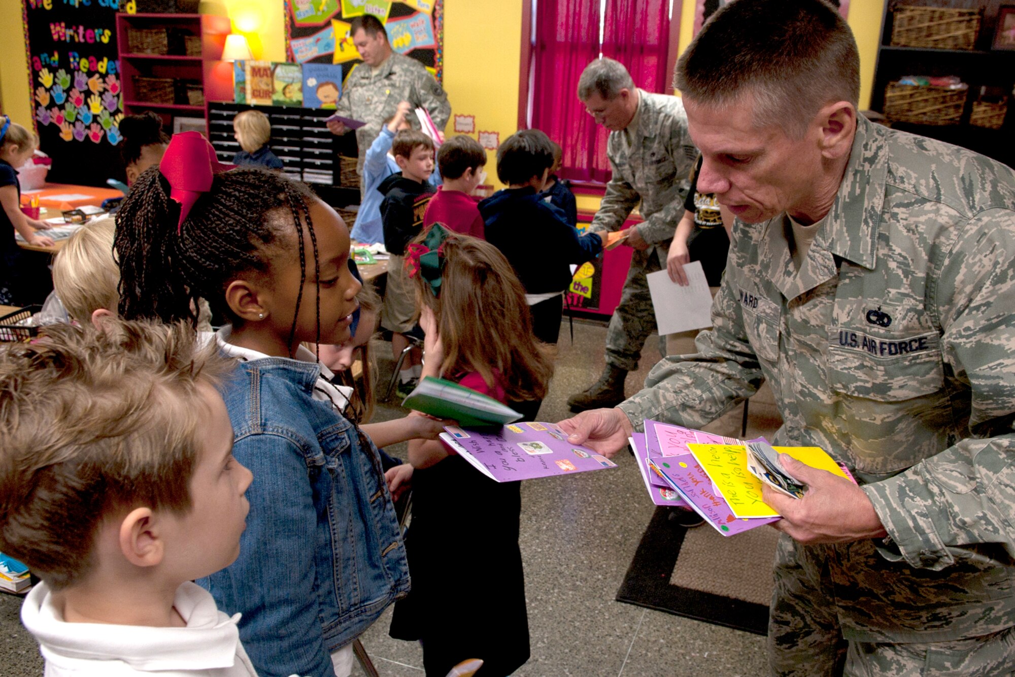 U.S. Air Force Tech. Sgt. David Ward, 917th Aircraft Maintenance Squadron, receives cards from students at the Phoenix Magnet Elementary School in Alexandria, Va., Nov. 10, 2011. The school hosted a group of 917th Fighter Group personnel who they have adopted to support during future deployments. (U.S. Air Force photo by Master Sgt. Greg Steele/Released)