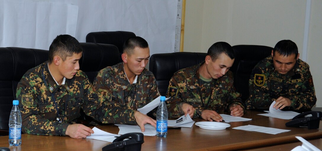 Soldiers from the Koi Tash Noncommissioned Officer Academy follow along with handouts during an enlisted professional military education instructor exchange at the Transit Center at Manas, Kyrgyzstan, Nov. 10. The event centered on the Airman Leadership School methods of course delivery and the four primary curriculum topics of expeditionary Airmen, supervisor of Airmen, military professionalism and supervisor communications. (U.S. Air Force photo/Tech. Sgt. Tammie Moore)