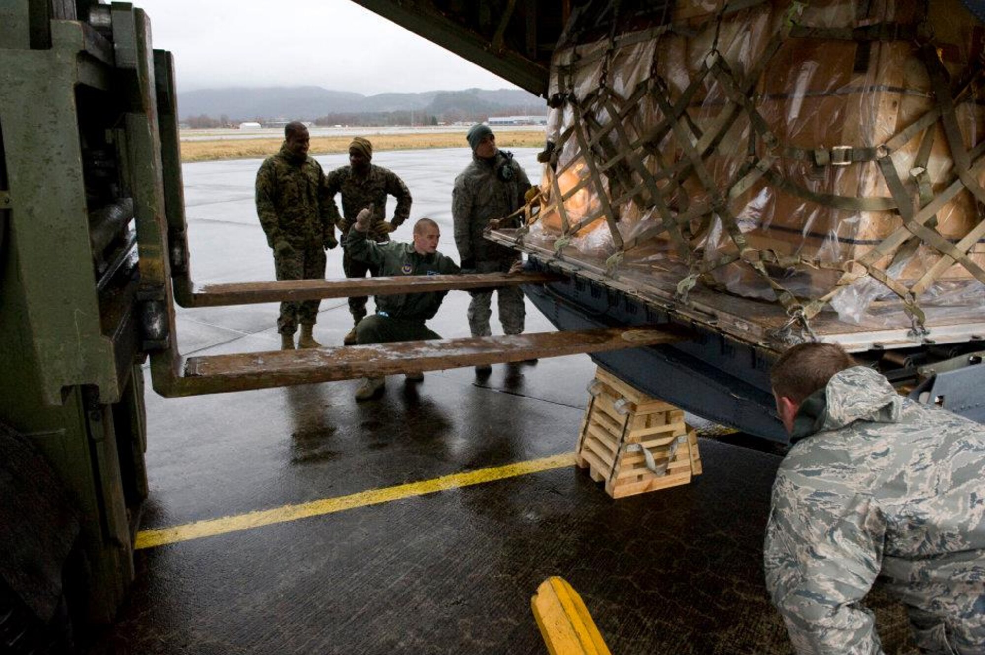 Members of the 37th Airlift Squadron, Norwegian Defense Logistic Organization/Marine Expeditionary Brigade and Marine Forces Europe load a C-130J Hercules aircraft with pallets of humanitarian supplies for transportation in Stjordal, Norway, Nov. 14, 2011. The effort is in support of the Turkey-led relief efforts following the Nov. 9, and Oct. 23, 2011, earthquake in Van province, Turkey. At the request of the Turkish government the Department of Defense has tasked U.S. European Command to airlift relief supplies to Van province. (U.S. Air Force photo/MSgt Wayne Clark, AFNE Regional News Bureau) (Released) Defense Media Activity