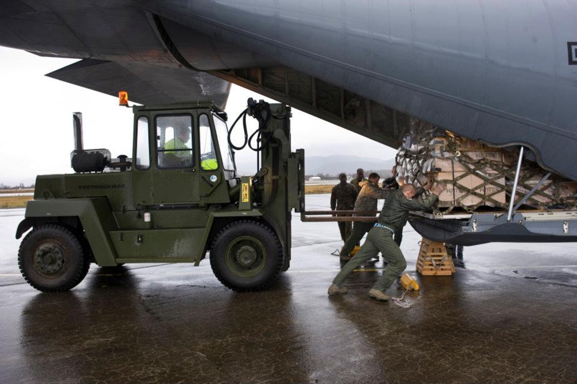Members of the 37th Airlift Squadron, Norwegian Defense Logistic Organization/Marine Expeditionary Brigade and Marine Forces Europe load a C-130J Hercules aircraft with pallets of humanitarian supplies for transportation in Stjordal, Norway, Nov. 14, 2011. The effort is in support of the Turkey-led relief efforts following the Nov. 9, and Oct. 23, 2011, earthquake in Van province, Turkey. At the request of the Turkish government the Department of Defense has tasked U.S. European Command to airlift relief supplies to Van province. (U.S. Air Force photo/MSgt Wayne Clark, AFNE Regional News Bureau) (Released) Defense Media Activity