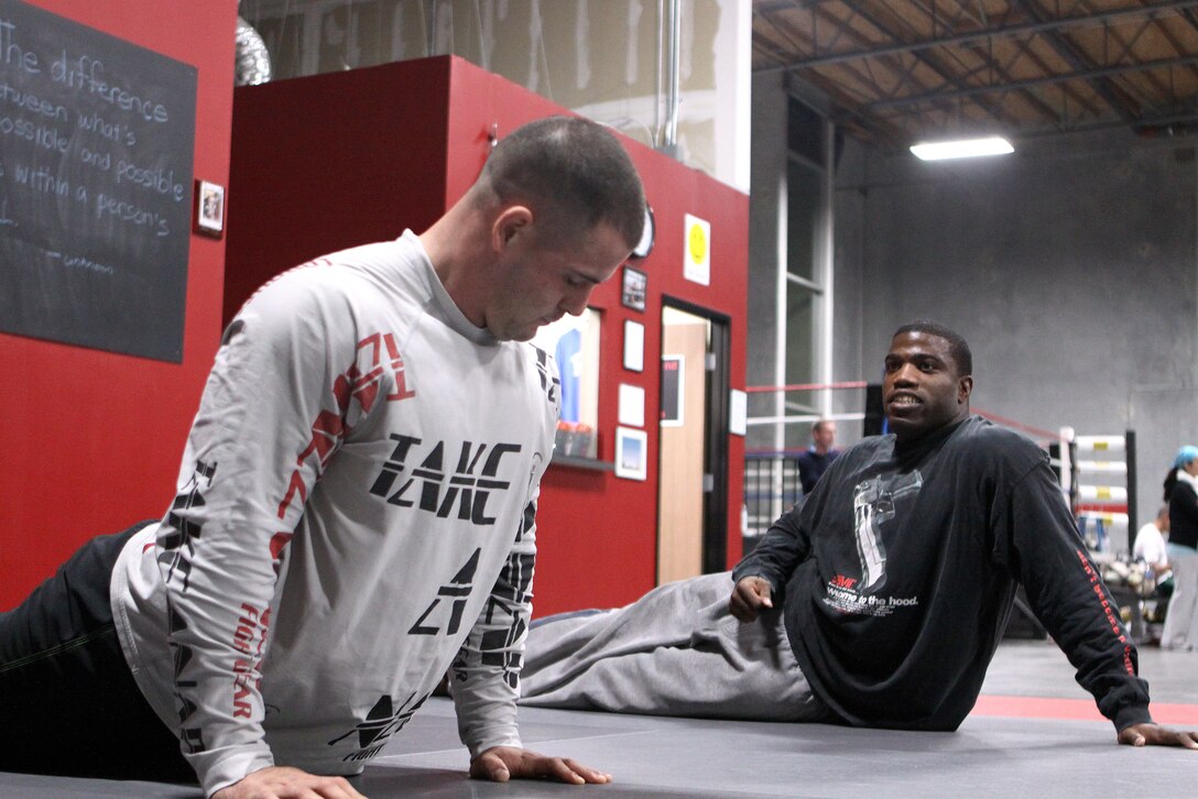 Sgt. Antonio I. Santiago (left, facing away), instructor and reserve integration noncommissioned officer, operations section, U.S. Marine Corps Forces, Pacific, answers questions during a Marine Corps Martial Arts Program class here Nov. 16. At the end of class, students are reminded that the fundamentals from the tan belt syllabus apply throughout all levels of the program.