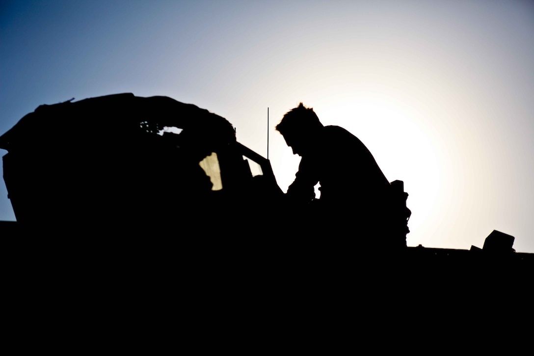 A Marine with 1st Battalion, 9th Marine Regiment, checks his equipment shortly after arriving at Patrol Base Kharaman at the end of a day’s patrol. The Marines conducted an eight-kilometer foot patrol on the third day of the Nawa Victory Walk across the district.