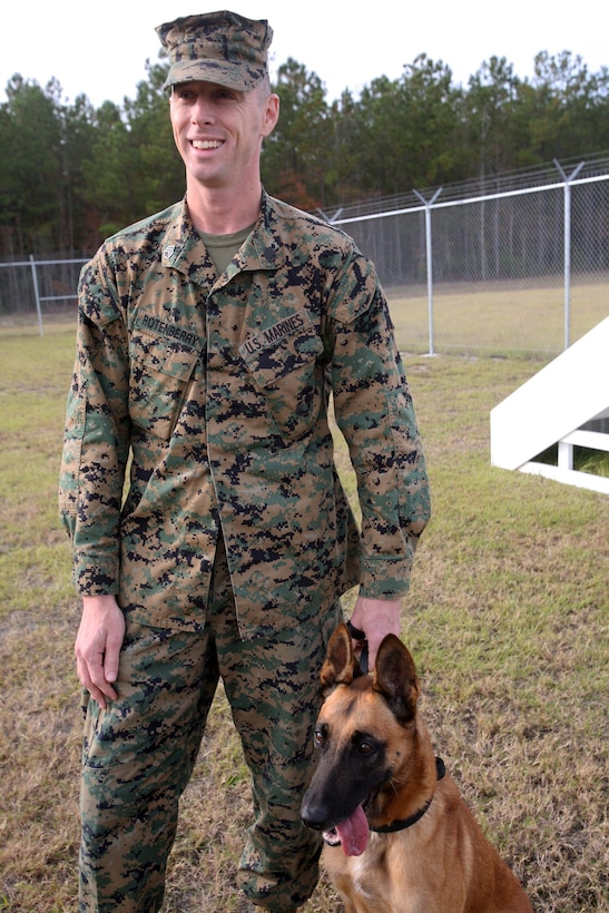 Staff Sgt. Charles T. Rotenberry, an assistant kennel master, with Military Working Dog Platoon, Military Police Support Company, 2nd Marine Headquarters Group, shows off one of the platoon’s working dogs aboard Marine Corps Base Camp Lejeune, N.C., Nov. 16. The dogs are used by the platoon to locate improvised explosive devices in Afghanistan as well as help track insurgents. However, on occasion they are used to assist in local searches. Recently the platoon successfully located a missing two-year-old girl.