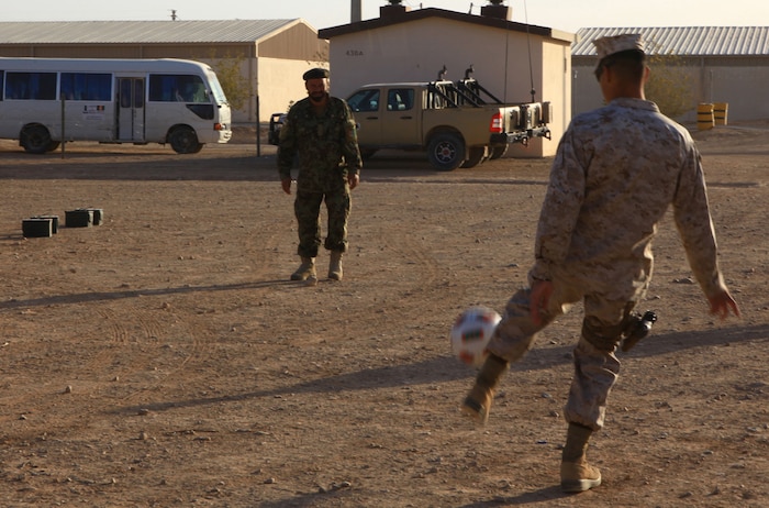 Cpl. Daniel Botero, a combat engineer with the Combat Logistics Battalion 1 Embedded Partnering Team, 2nd Marine Logistics Group (Forward), kicks a soccer ball around Camp Shorabak, Afghanistan, with the EPT's Afghan National Army Counterparts, Nov. 16. Botero was diagnosed with cancer in 2009, but thanks to chemotherapy and two surgeries, he has been in remission since October 2010.  (U.S. Marine Corps photo by Cpl. Katherine M. Solano)