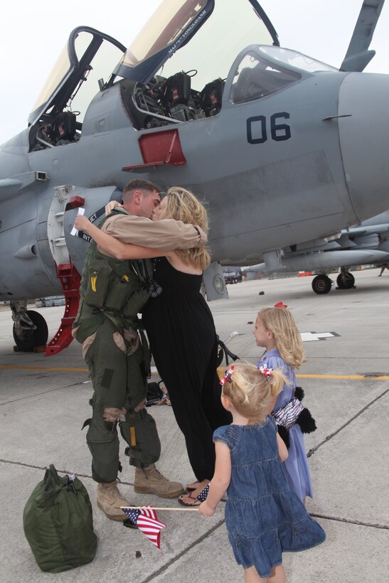Capt. Jon C. Banks, an EA-6B pilot, shares his first kiss in months with his wife, Deborah, in front of their children, Magnolia and Amalia, on the MCAS Cherry Point flightline when Marine Tactical Electronic Warfare Squadron 4 returned from Afghanistan Nov. 16.