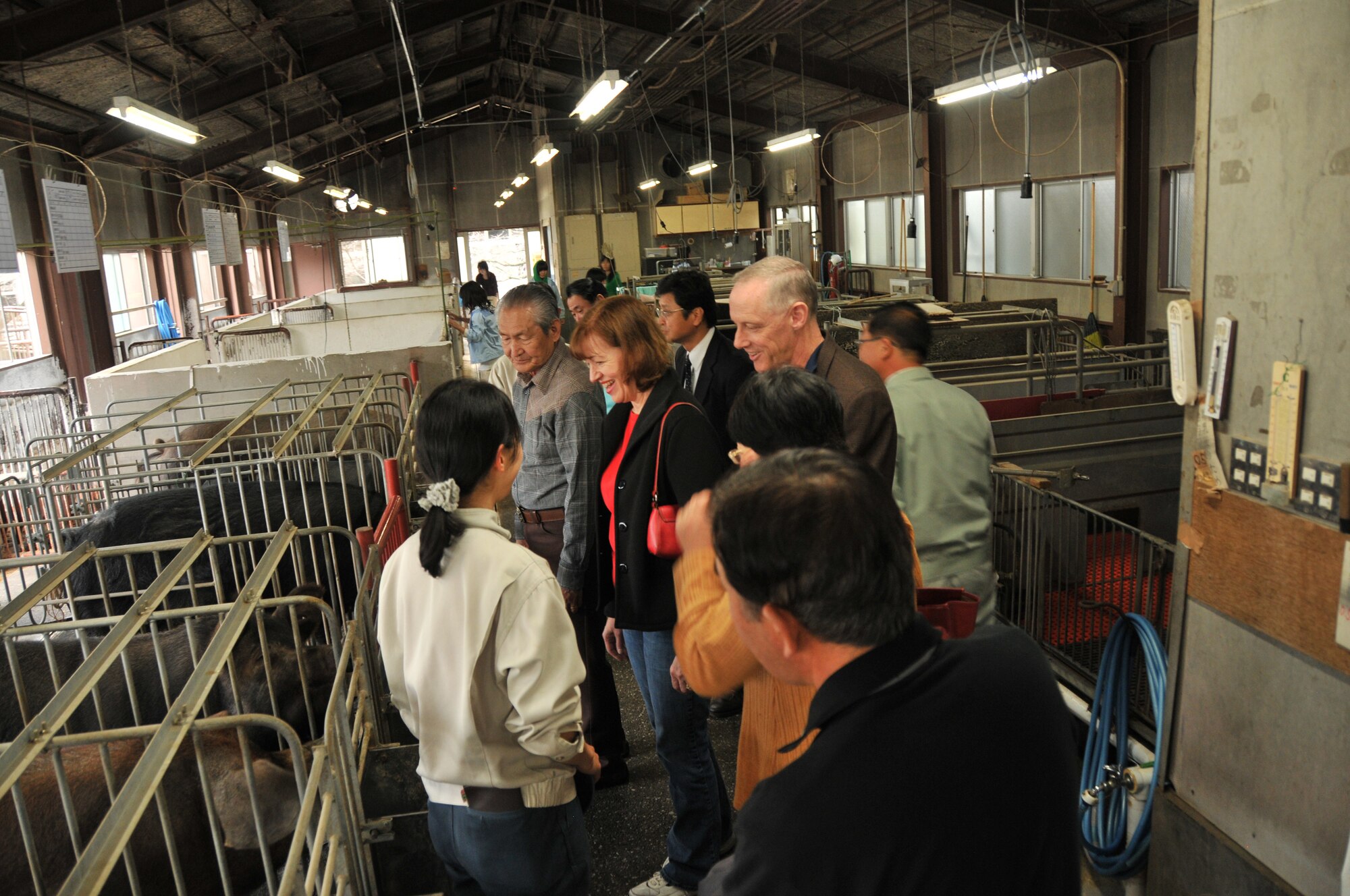 MIZUHO, Japan -- Col. Otto Feather, 374th Airlift Wing commander, and wife, Nancy, tour a hog barn during their Mizuho Nogei High School visit, Nov. 11, 2011, in Mizuho, Japan. During their visit, students from the livestock science department explained how their agricultural department operates and conducted a tour. (U.S. Air Force photo/Airman 1st Class Desiree Economides)