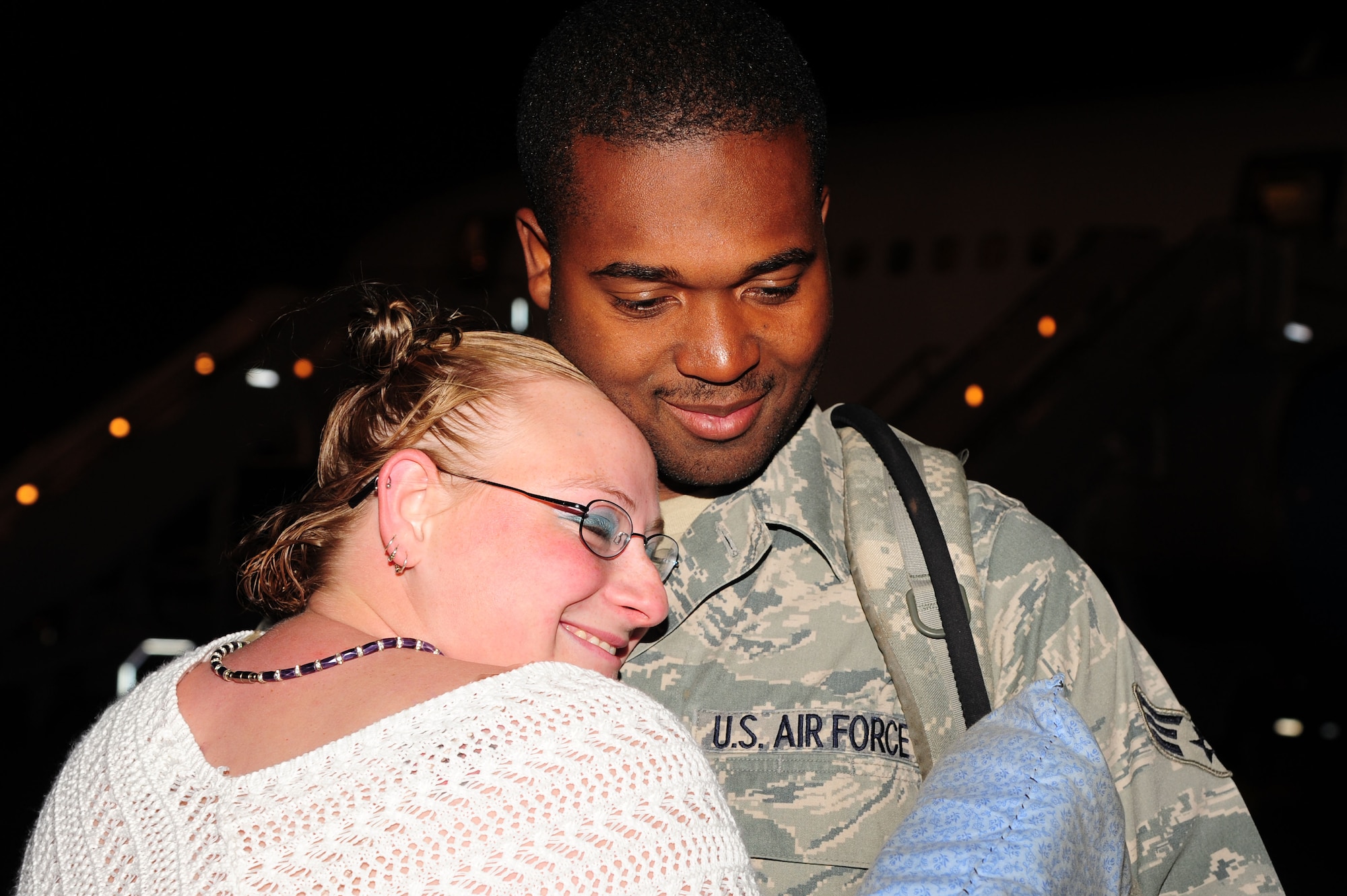 Senior Airman Eric Spencer, a member of the 19th Emergency Maintenance Squadron, embraces his wife Amanda, Wednesday, upon returning from a deployment supporting combat operations in Southwest Asia. Families and friends weathered the chilly temperatures outside and cheered raucously when nearly 200 Black Knights returned home after more than six months abroad. (U.S. Air Force photo by Airman 1st Class Kaylee Clark)