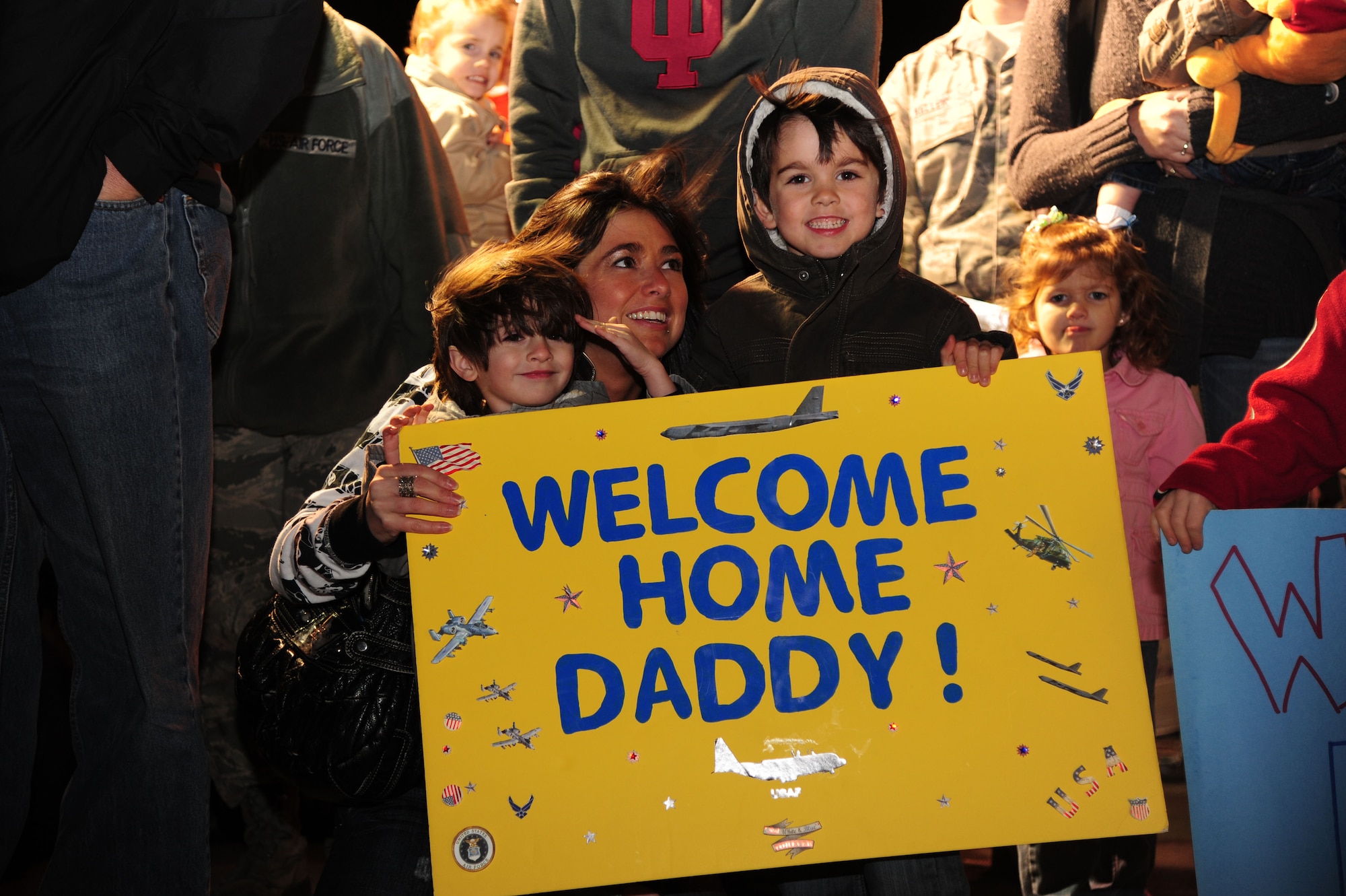 Amanda Gloris, wife of Tech. Sgt. Robert Gloris, a member of the 19th Aircraft Maintenance Squadron, and sons Ian, 5, and Dylan, 3, wait to greet their husband and father Wednesday, upon his return from a deployment supporting combat operations in Southwest Asia. Families and friends weathered the chilly temperatures outside and cheered raucously when nearly 200 Black Knights returned home after more than six months abroad. (U.S. Air Force photo by Airman 1st Class Kaylee Clark)