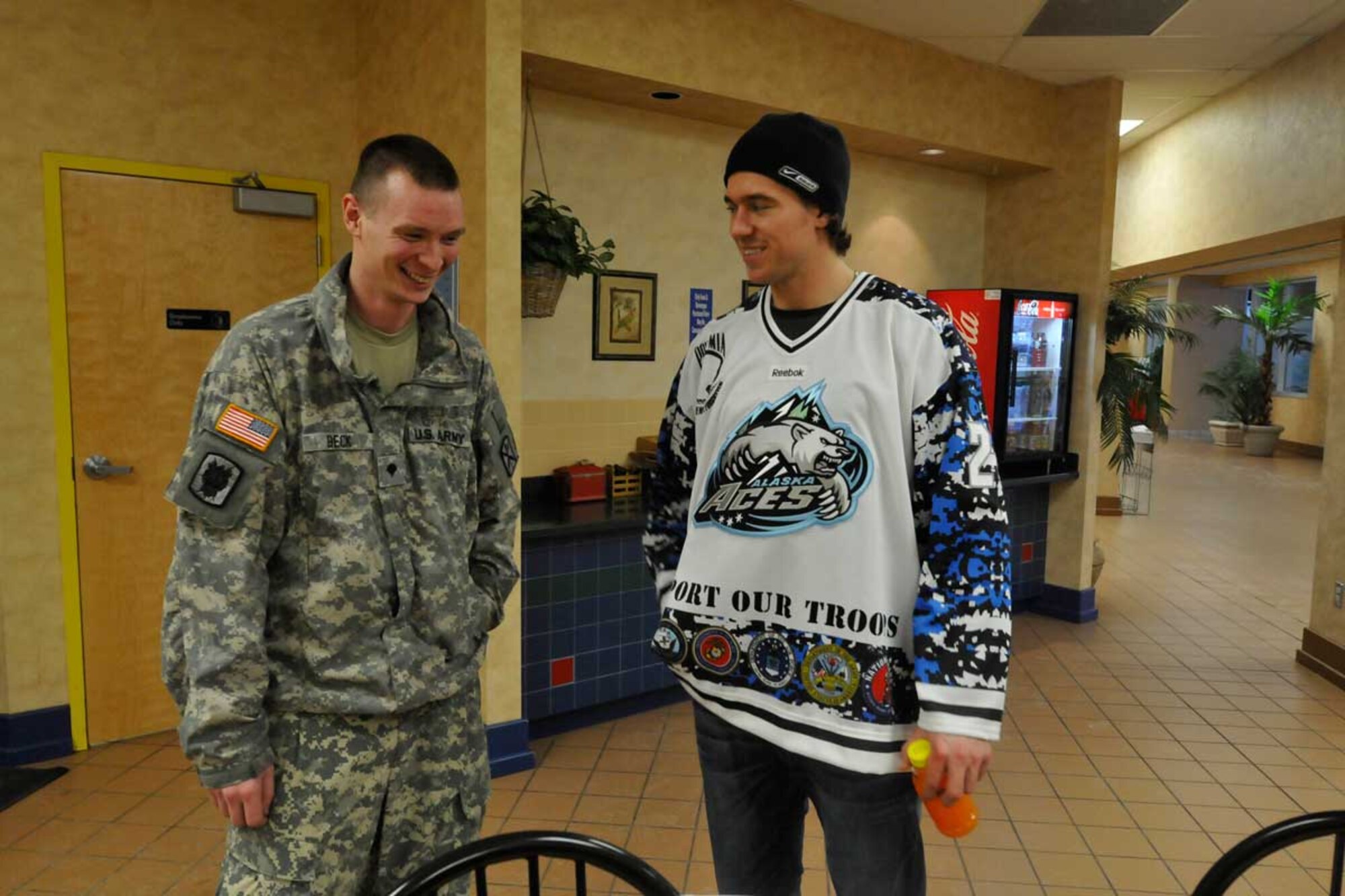 Army Spc. Ryan Beck, Company C, 307th Expeditionary Signal Battalion, shares memories of growing up in Cleveland, Ohio, with Alaska Aces hockey player Russ Sinklewich. The Alaska Aces were on base for a broom ball game with Soldiers and Airmen at the Elmendorf fi tness center Nov. 9. (U.S. Air Force photo/Steve White)