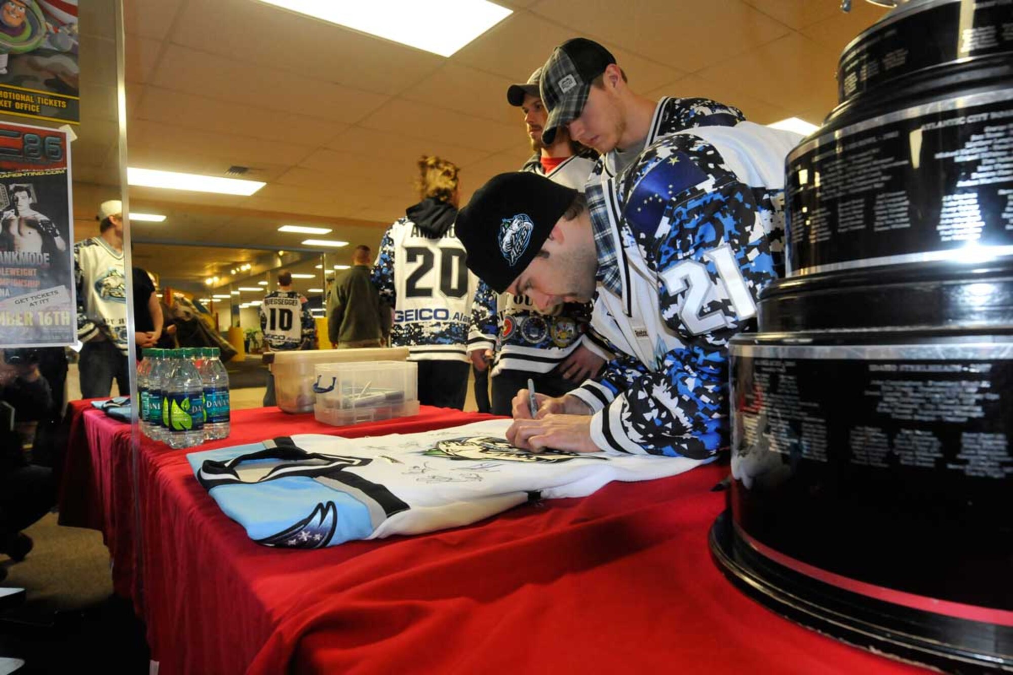Aces team members autograph jerseys and other items for Soldiers, Airmen and family members at the Arctic Oasis after the game. (U.S. Air Force photo/Steve White)