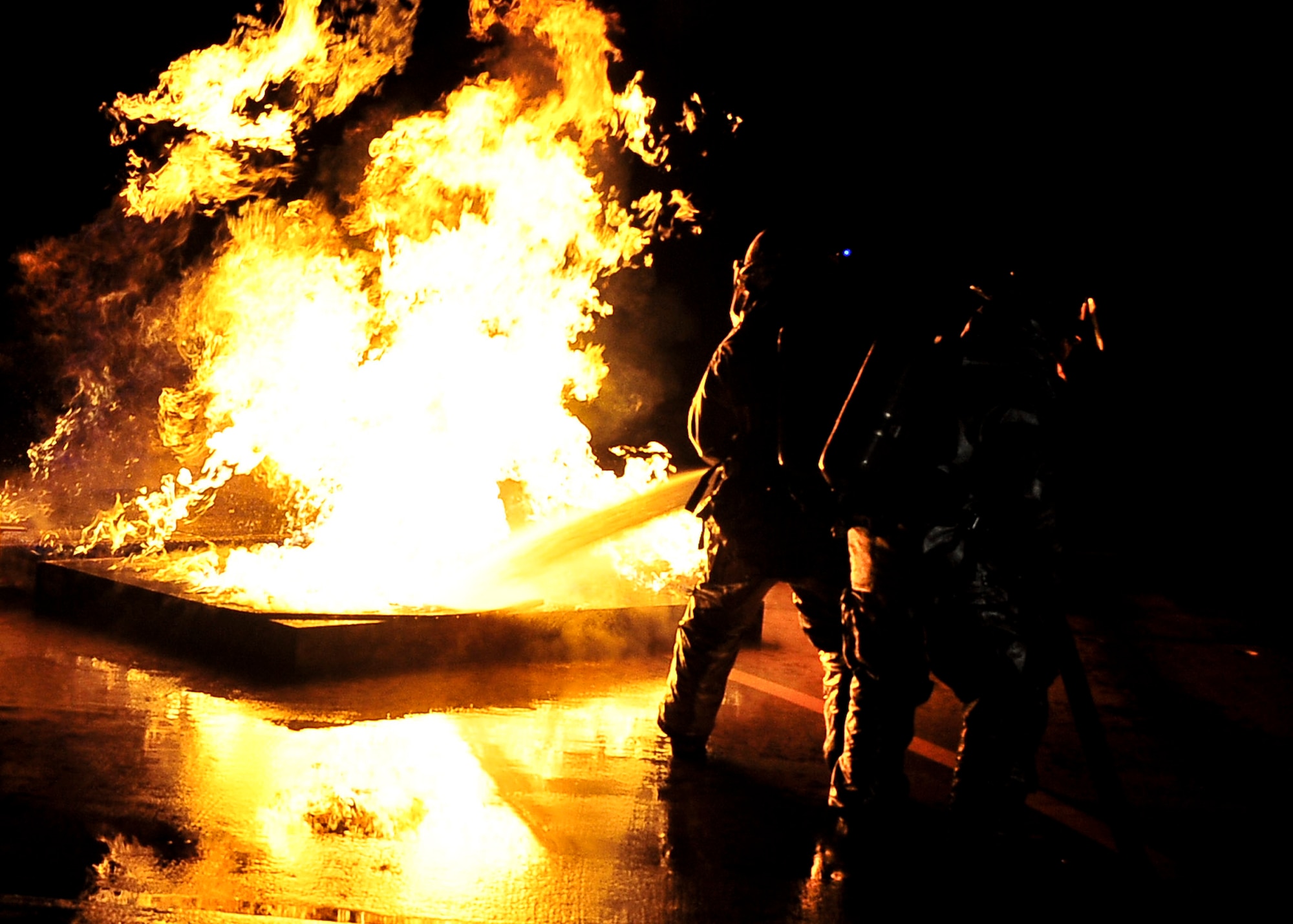 Airmen from the 51st Civil Engineer Squadron, extinguish a fire started after a simulated plane crash during   Beverly Bulldog 11-03, a peninsula-wide operational readiness exercise Nov. 14, 2011. The exercise allows Airmen to demonstrate their ability to complete the mission in a simulated hostile environment while executing their primarily duties. (U.S. Air Force photos/Senior Airman Adam Grant)