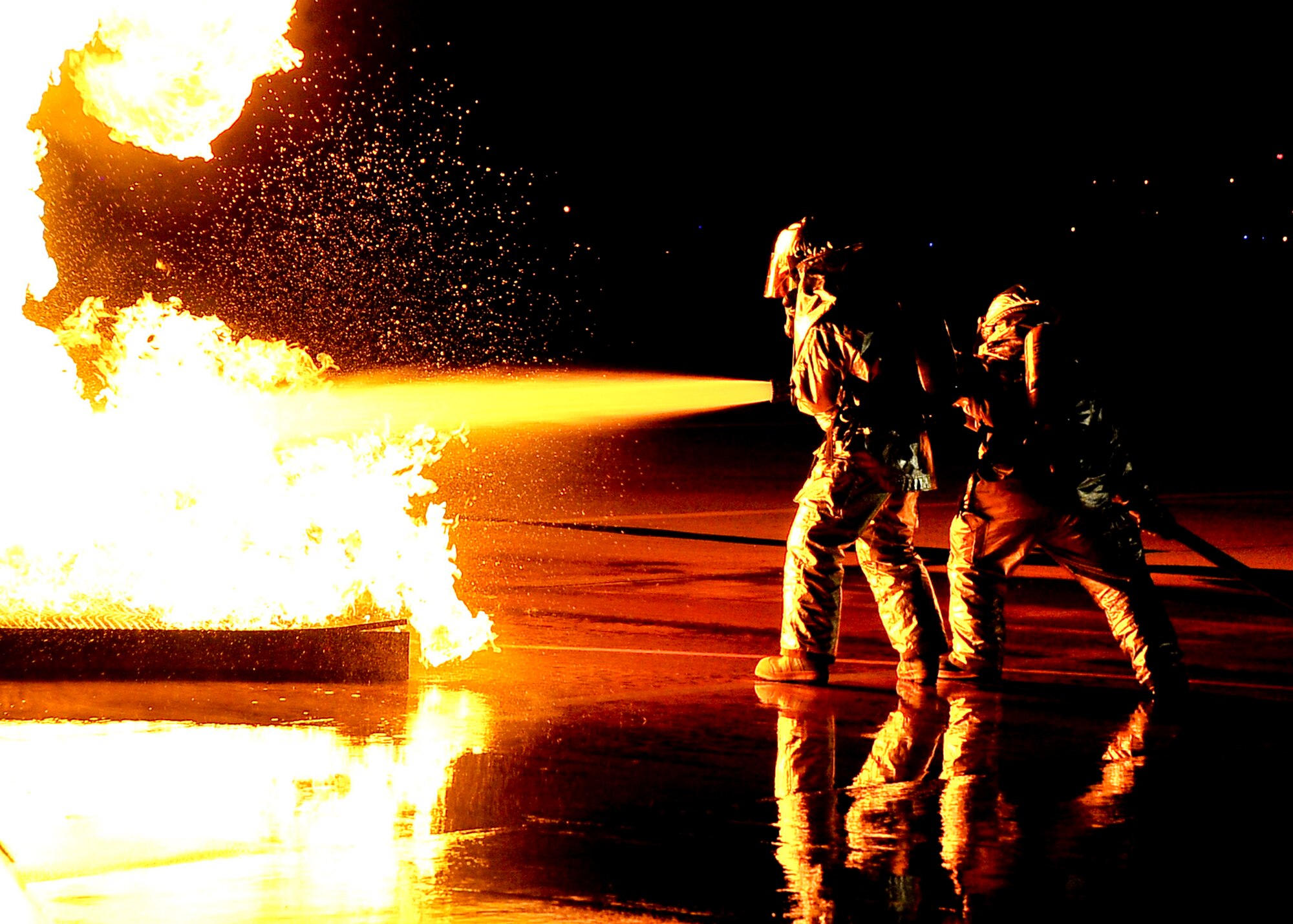 Two firefighters from the 51st Civil Engineer Squadron extinguish a fire started after a simulated plane crashed during Beverly Bulldog 11-03, a peninsula-wide operational readiness exercise Nov. 14, 2011. Beverly Bulldog 11-03 scenarios test team Osan’s ability to defend the base and conduct daily operations in a combat environment. (U.S. Air Force photos/Senior Airman Adam Grant)