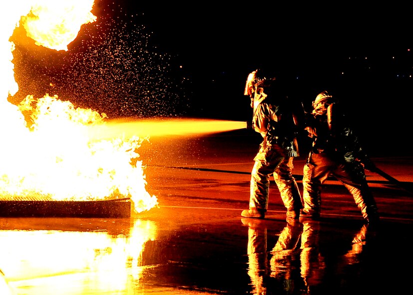 Two firefighters from the 51st Civil Engineer Squadron extinguish a fire started after a simulated plane crashed during Beverly Bulldog 11-03, a peninsula-wide operational readiness exercise at Osan Air Base, Republic of Korea, Nov. 14. Beverly Bulldog 11-03 scenarios test team Osan’s ability to defend the base and conduct daily operations in a combat environment. (U.S. Air Force photo/Senior Airman Adam Grant) 

