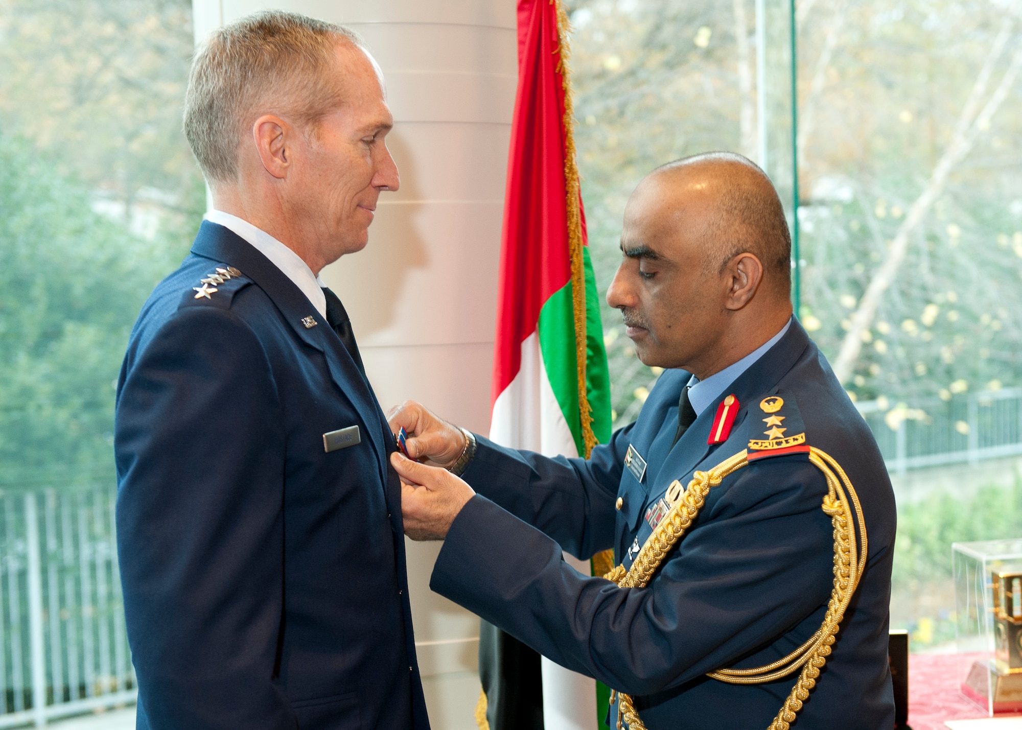 The United Emirates (UAE) Air Attaché Col. Abdelrahmn Al-Mazmiby affixes the Foreign Operations Missions Medal to Air Combat Command commander U.S. Air Force Gen. Mike Hostage III during a ceremony at the UAE Embassy, Washington D.C. on Nov. 15, 2011. (U.S. Air Force photo by Jim Varhegyi/Released)