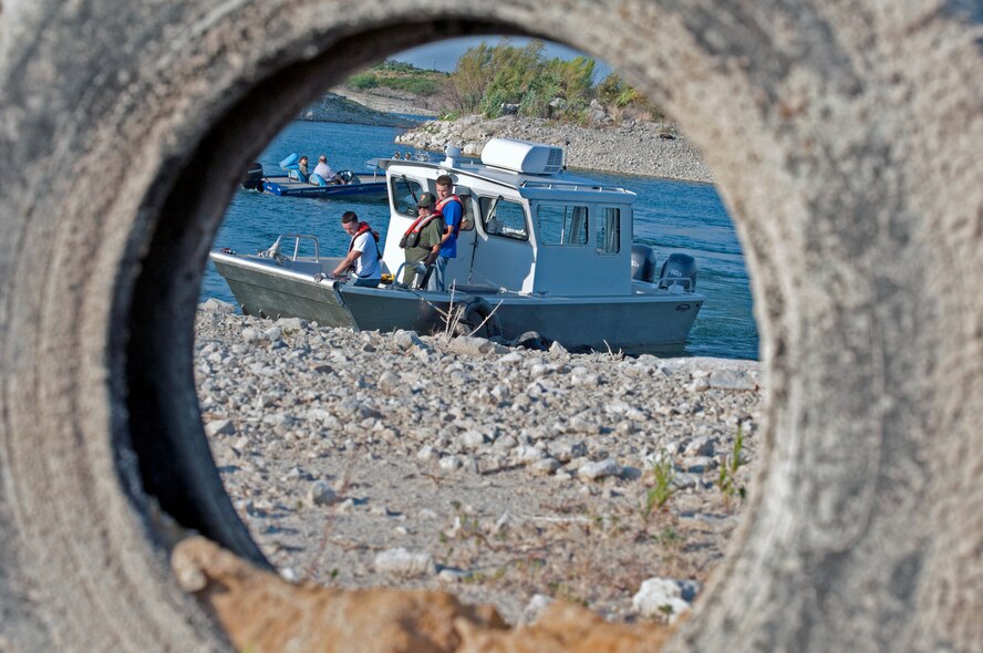 LAUGHLIN AIR FORCE BASE, Texas – Volunteers drag dozens of beached tires to get picked up at Lake Amistad Sept. 2. The old WWII Jeep tires were installed in the marina decades ago by the Army Corps of Engineers to protect the marina from high winds. Powerful storms throughout the last 30 years damaged the structure and ultimately gave way in 2011, littering the shorelines. (U.S. Air Force photo/Senior Airman Scott Saldukas)