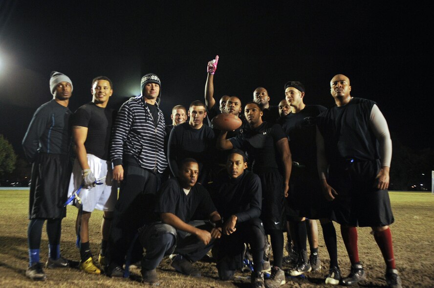 The 23rd and 347th Operation Support Squadron team poses for the camera after winning the intramural flag football championship game at Moody Air Force Base, Ga., Nov. 10, 2011. The team won 12-3 and sealed the deal with an interception by Stan Nelson during the final moments of the game. (U.S. Air Force photo by Airman 1st Class Olivia Dominique/Released)