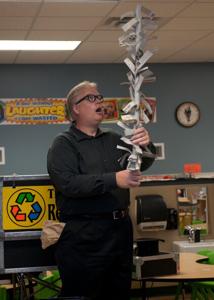 Greg Allen, The Magic of Recycling presenter, performs a newspaper magic trick for children at the Child Development Center, Moody Air Force Base, Ga., Nov. 16, 2011. The trick was to inform the children about how many trees are cut down to make paper. Allen entertained the kids with 45 minutes of interactive magic tricks which demonstrated the benefits that recycling can have on the environment and where garbage goes if not recycled. (U.S. Air Force photo by Senior Airman Eileen Meier/Released)