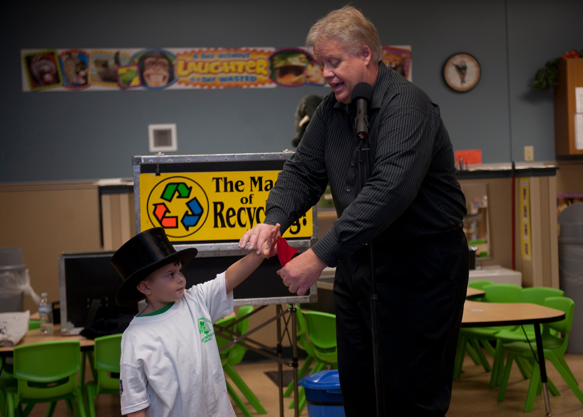 Mason Hudgins, son of U.S. Air Force Tech. Sgt. Jedediah Hudgins, 23rd Security Forces Squadron, assists Greg Allen, The Magic of Recycling presenter, with a magic trick at the Child Development Center, Moody Air Force Base, Ga., Nov. 16, 2011. Allen has performed the “Magic of Recycling” presentation for 15 years and will travel to different schools in Lowndes County to help educate children on the importance of recycling. (U.S. Air Force photo by Senior Airman Eileen Meier/Released)