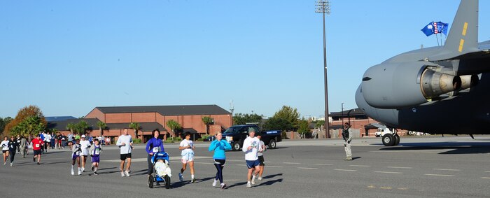 Team Charleston personnel and local civilians run along side a 437th Airlift Wing C-17 Globemaster III as part of the third annual Run the Runway 5K event honoring Brig. Gen. Thomas Mikolajcik Nov. 11 at Joint Base Charleston- Air Base.  The 5k course took place on JB Charleston's runway.  The event was held to raise awareness of Amyotrophic Lateral Sclerosis. (U.S. Air Force photo/Tech Sgt. Chrissy Best)
