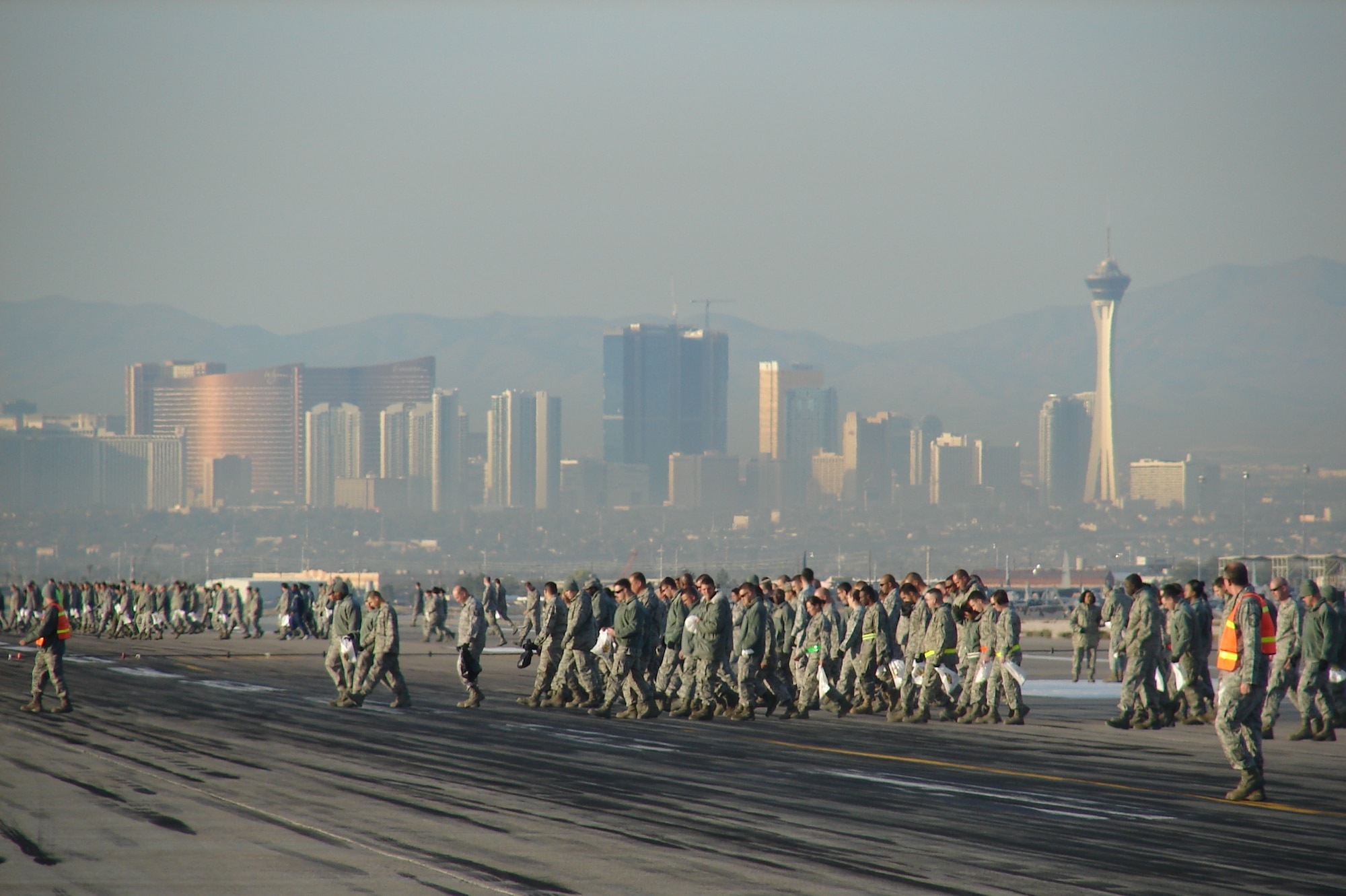 Nellis Airmen participate in a base-wide FOD Walk the morning after Aviation Nation comes to a close Nov. 14, 2011, on the flightline at Nellis Air Force Base, Nev.  The purpose of a FOD walk is to collect any foreign objects, such as small rocks and trash, and to dispose of them so they do not cause damage to the aircraft on the flightline.  (U.S. Air Force photo by Lawrence Crespo/Released)