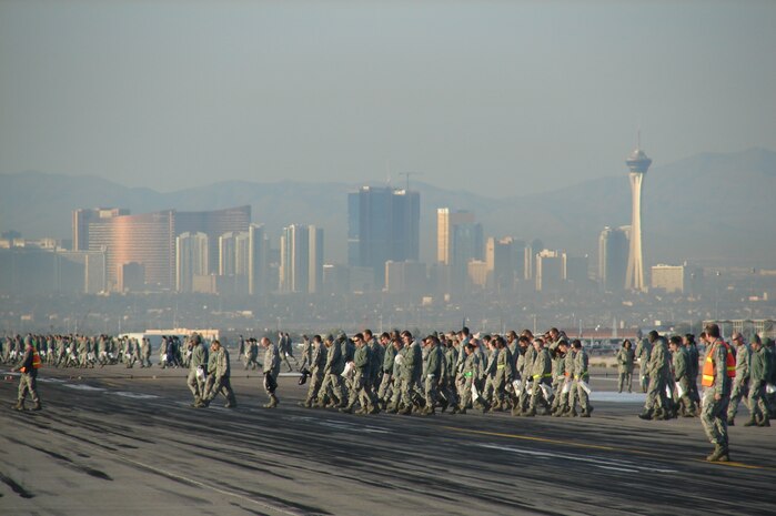 Nellis Airmen participate in a base-wide FOD Walk the morning after Aviation Nation comes to a close Nov. 14, 2011, on the flightline at Nellis Air Force Base, Nev.  The purpose of a FOD walk is to collect any foreign objects, such as small rocks and trash, and to dispose of them so they do not cause damage to the aircraft on the flightline.  (U.S. Air Force photo by Lawrence Crespo/Released)