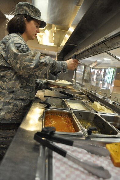 Tech. Sgt. Sarah Butcher, 627th Force Support Squadron dining facility manager, serves a Fit Plate meal at the Olympic Dining Facility on Joint Base Lewis-McChord, Wash. “There are healthy options at every meal,” said Butcher. “But this way, it’s easier and quicker for people to identify the best options. Instead of looking around, they can just tell the staff they want to order the Fit Plate.” (U.S. Air Force photo/Airman 1st Class Leah Young)
