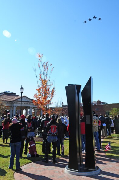 Spectators watch as four F-15E Strike Eagles from the 333rd Fighter Squadron perform a fly-over during the dedication of the Wayne County Veteran's Memorial in downtown Goldsboro, N.C., Nov. 11, 2011. The 333rd Fighter Squadron is one of four flying squadrons on Seymour Johnson Air Force Base. (U.S. Air Force photo by Senior Airman Rae Perry)