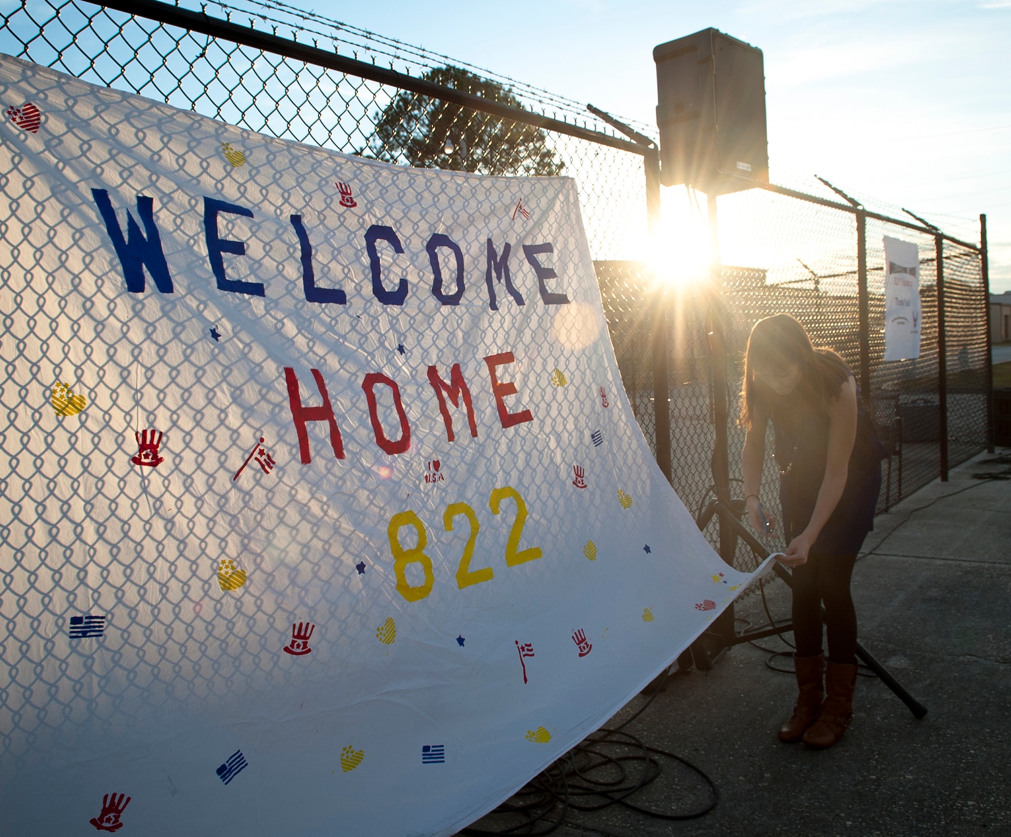 Kristen McSpadden, spouse of U.S. Air Force Capt. Cecil McSpadden, 822nd Base Defense Squadron officer in charge of intelligence, hangs a sign that welcomes home 822nd Base Defense Squadron members during a deployment return at Moody Air Force Base, Ga., Nov. 12, 2011. The 822nd Base Defense Squadron returned from a six-month deployment in Iraq where they supported Operation New Dawn. (U.S. Air Force photo by Airman 1st Class Joshua Green/Released)                     
       
          
           
        
