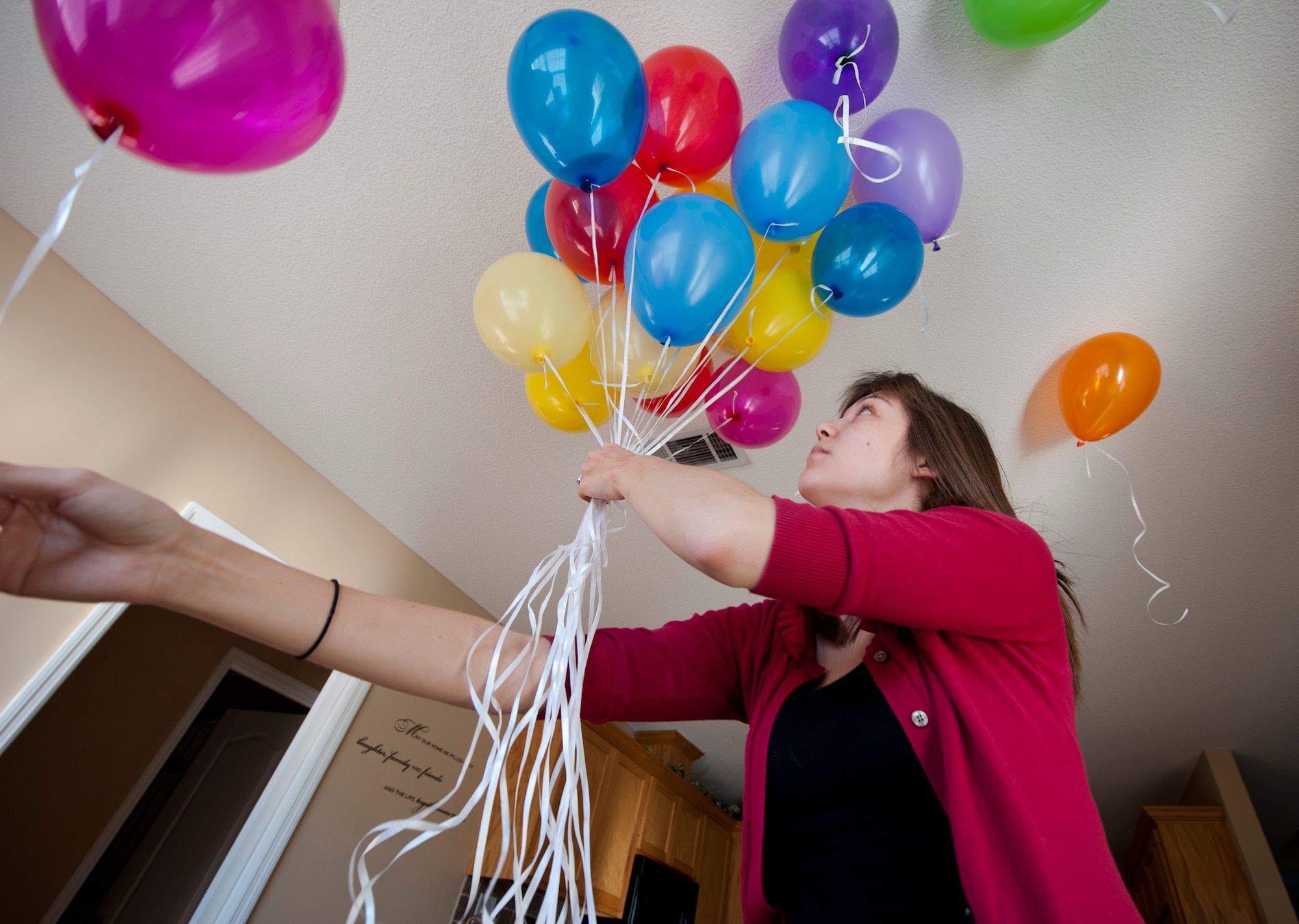 Kristen McSpadden, spouse of U.S. Air Force Capt. Cecil McSpadden, 822nd Base Defense Squadron officer in charge of intelligence, gathers balloons to hand out to family and friends during a deployment return in Valdosta, Ga., Nov. 12, 2011. The balloons were for the children waiting for their parents return after a six-month deployment. (U.S. Air Force photo by Airman 1st Class Joshua Green/Released)          
