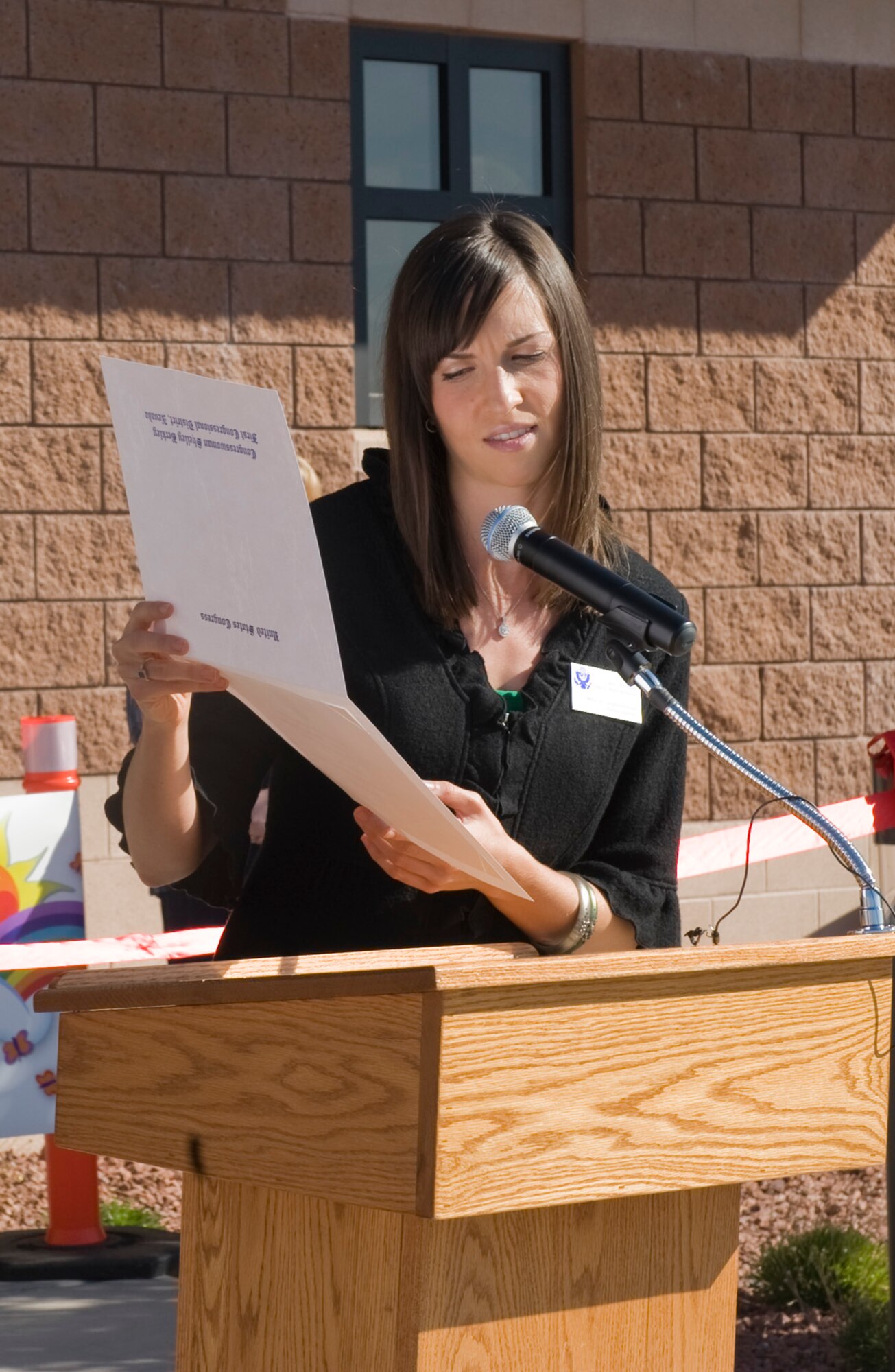 Jessi Hotchkiss presents a congressional recognition certificate on behalf of Congresswomen Shelly Berkley to the Child Development Center I during its grand opening Nov. 14, 2011, on Nellis Air Force Base, Nev. More than 90 people were in attendance for the ceremony.  (U.S Air Force photo by Senior Airman Stephanie Rubi / Released) 
