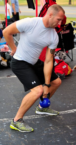Staff Sgt. Chastin Warner, 20th Civil Engineer Squadron firefighter, warms up for his race by lifting a kettle ball at the Scott Firefighter Combat Challenge world competition at Myrtle Beach, S.C. Nov. 15, 2011. Warner's individual race time inducted him into the Lion's Den, a group for the elite compeititors, making him one of the top firefighters in this competition in the world. (U.S. Air Force photo/Airman 1st Class Daniel Phelps/Released)