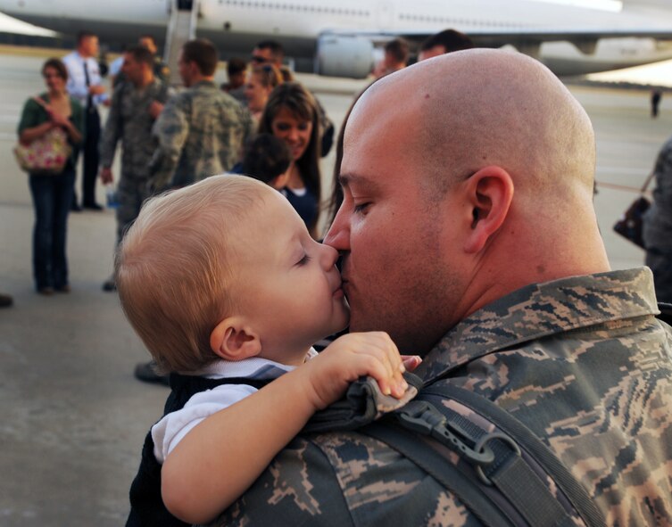 U.S. Air Force Staff Sgt. Timothy Lewig, 55th Fighter Squadron Aircraft Maintenance Unit weapons expeditor, kisses his son Korbyn Lee after returning home from supporting Operation Unified Protector, at Shaw Air Force Base, S.C., Nov. 14, 2011. Operation Unified Protector was a coalition of North Atlantic Treaty Organization allies protecting civilians under the attack of Libya, enforcing an embargo and maintaining a no-fly zone. (U.S. Air Force photo by Airman 1st Class Tabatha Duarte/Released)