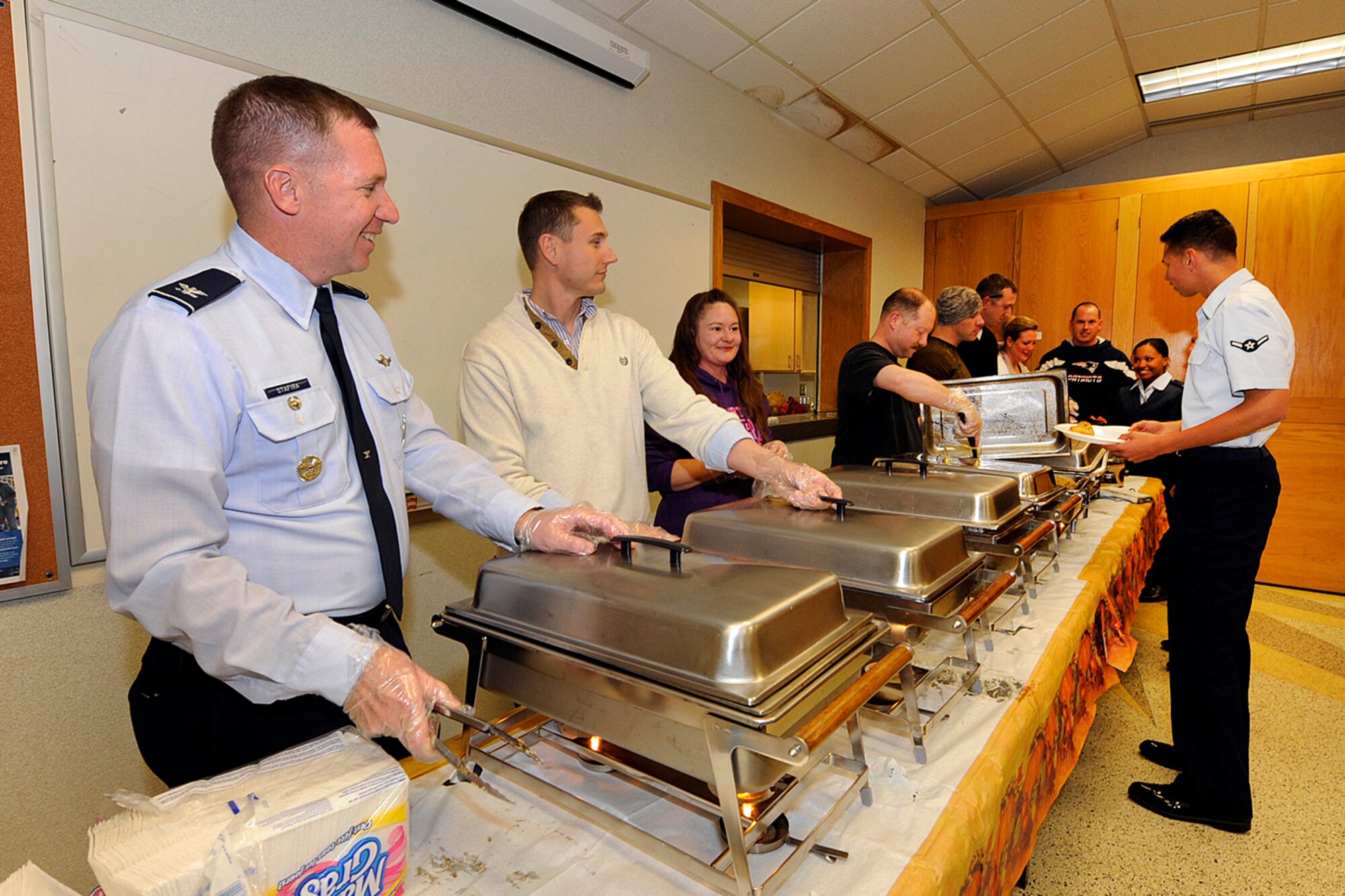 PETERSON AIR FORCE BASE, Colo. – Col. Stanley Stafira (left), 50th Space Wing vice commander, and volunteers from Peterson and Schriever Air Force bases serve dorm residents a traditional Thanksgiving feast Nov. 14 at the Peterson chapel. Various commanders and other Air Force volunteers gave their time to serve the junior enlisted a hot holiday meal in advance of the actual holiday. (U.S. Air Force photo/Rob Bussard)