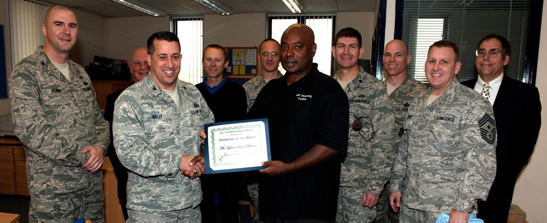 RAF ALCONBURY, United Kingdom - Col. Brian Kelly presents the Innovator of the Month Award to Sylvan Duncan, 423rd Cvil Engineer Squadron. Duncan's innovation was to discontinue maintenance services for housing units declared surplus and will no longer be occupied saving more than $280,000. (U.S. Air Force photo by Senior Airman Joel Mease)