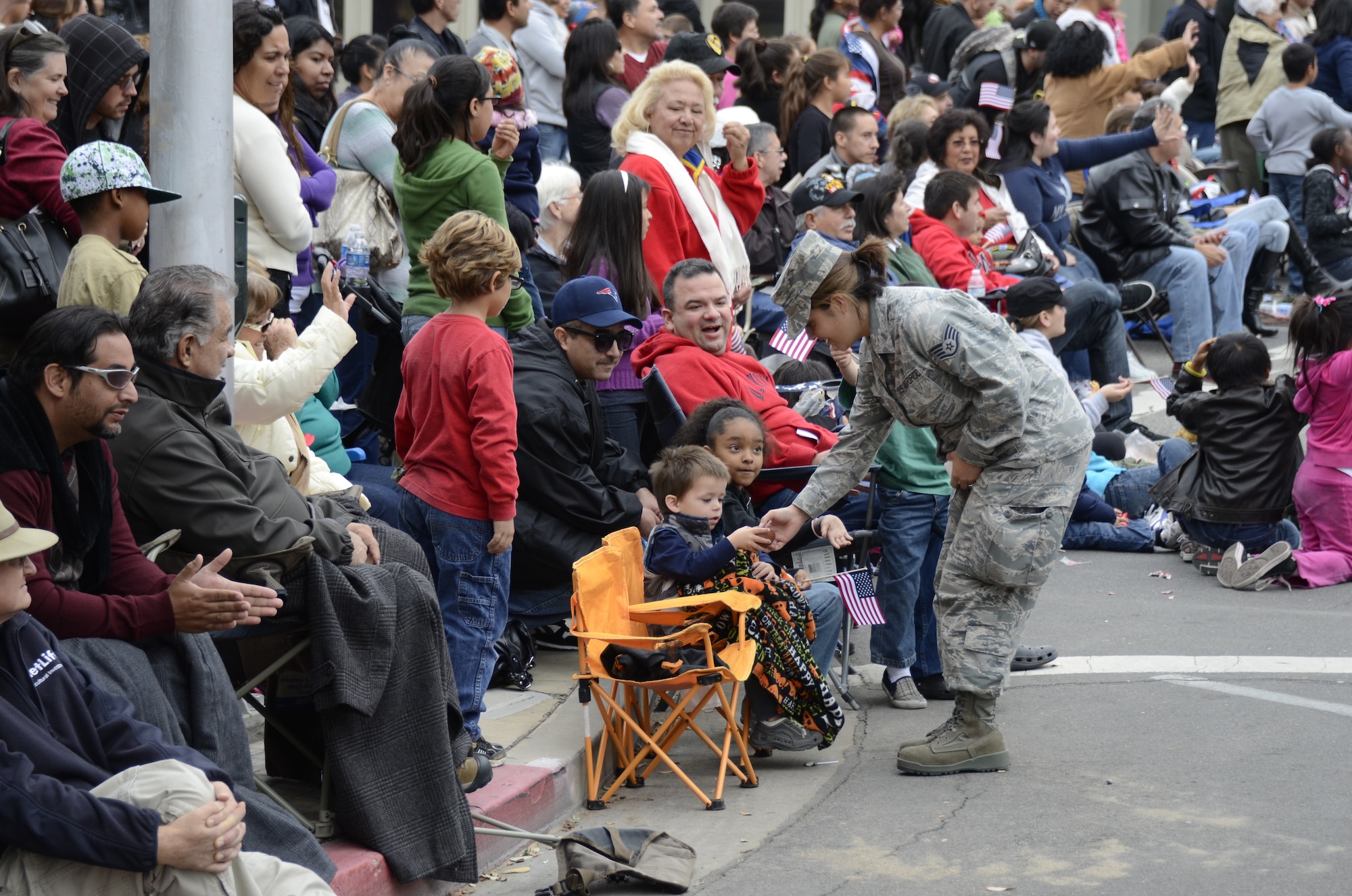 U.S. Air Force Staff Sgt. Nakia Weis from the 144th Medical Group, California Air National Guard, greets a young spectator during the 92nd Annual Fresno Veterans Day Parade on Nov. 11, 2011.  The parade is considered to be the largest Veterans Day event west of the Mississippi.  (U.S. Air Force photo by SMSgt. Chris Drudge)