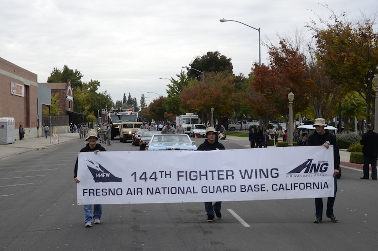 Members of the 144th FighterWing's Student Flight, California Air National Guard, carry the wing's banner through the streets of downtown Fresno during the 92nd Annual Veterans Day Parade on Nov. 11, 2011.  The wing had more than 30 volunteers and 13 vehicles in the parade stretching the length of a football field.  (U.S. Air Force photo by SMSgt. Chris Drudge)