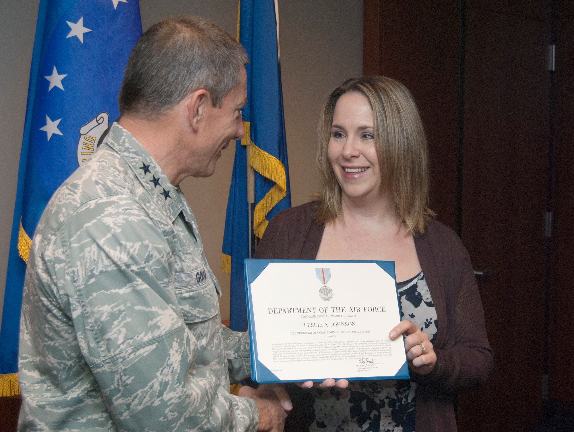 Leslie Johnson, right, receives a Command Civilian Award for Valor from Air Force Academy Superintendent Lt. Gen. Mike Gould during a senior staff meeting Nov. 16, 2011. Johnson risked her own safety to help a 21-year-old Colorado Springs, Colo., woman get away from an ex-boyfriend allegedly intent on killing her. (U.S. Air Force photo/Don Branum)