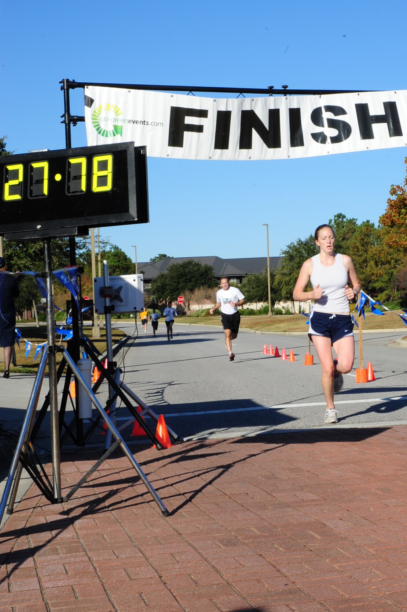 Amy Layne runs across the finsih line as the first female with a time of 27:78 during the third annual Run the Runway 5K event honoring Brig. Gen.  Thomas Mikolajcik Nov. 11 at Joint Base Charleston - Air Base.  The 5k course took place on JB Charleston's runway.  The event was held to raise awareness of Amyotrophic Lateral Sclerosis.  Layne is the wife of 1st Lt. Aleks Layne assigned to the 17th Airlift Squadron, 437th Airlift Wing.  (U.S. Air Force photo/Tech. Sgt. Chrissy Best) 

