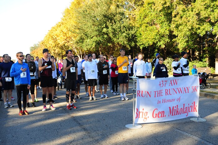 Team Charleston personnel and local civilians pay their respect to the National Anthem prior to starting the third annual Run the Runway 5K event honoring Brig. Gen  Thomas Mikolajcik Nov. 11 at Joint Base Charleston - Air Base. The 5k course took place on JB Charleston's runway.  The event was held to raise awareness of Amyotrophic Lateral Sclerosis. (U.S. Air Force photo/Tech. Sgt. Chrissy Best) 

